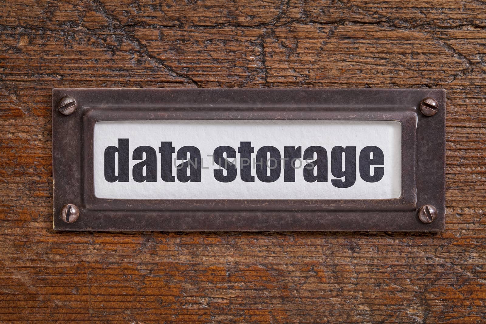 data storage  - file cabinet label, bronze holder against grunge and scratched wood