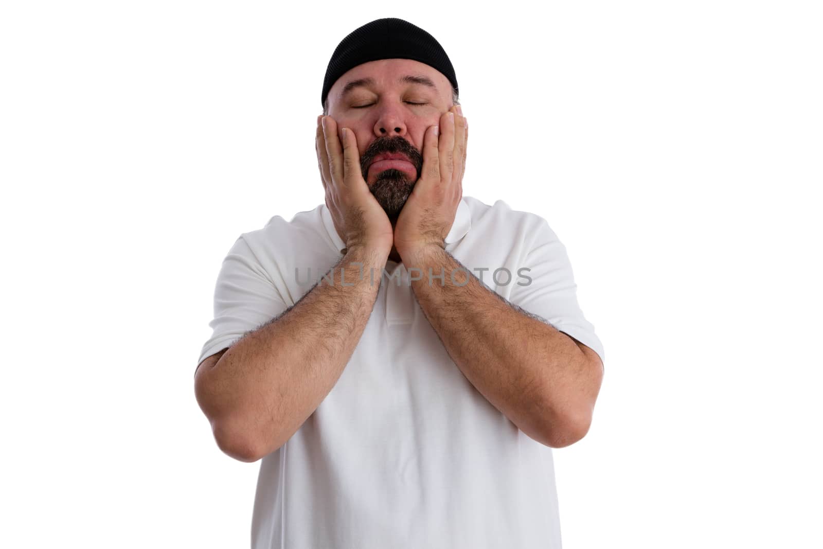 Sinful man seeking absolution praying to God with his hands to his cheeks, eyes closed and a devout expression as he seeks forgiveness, isolated on white