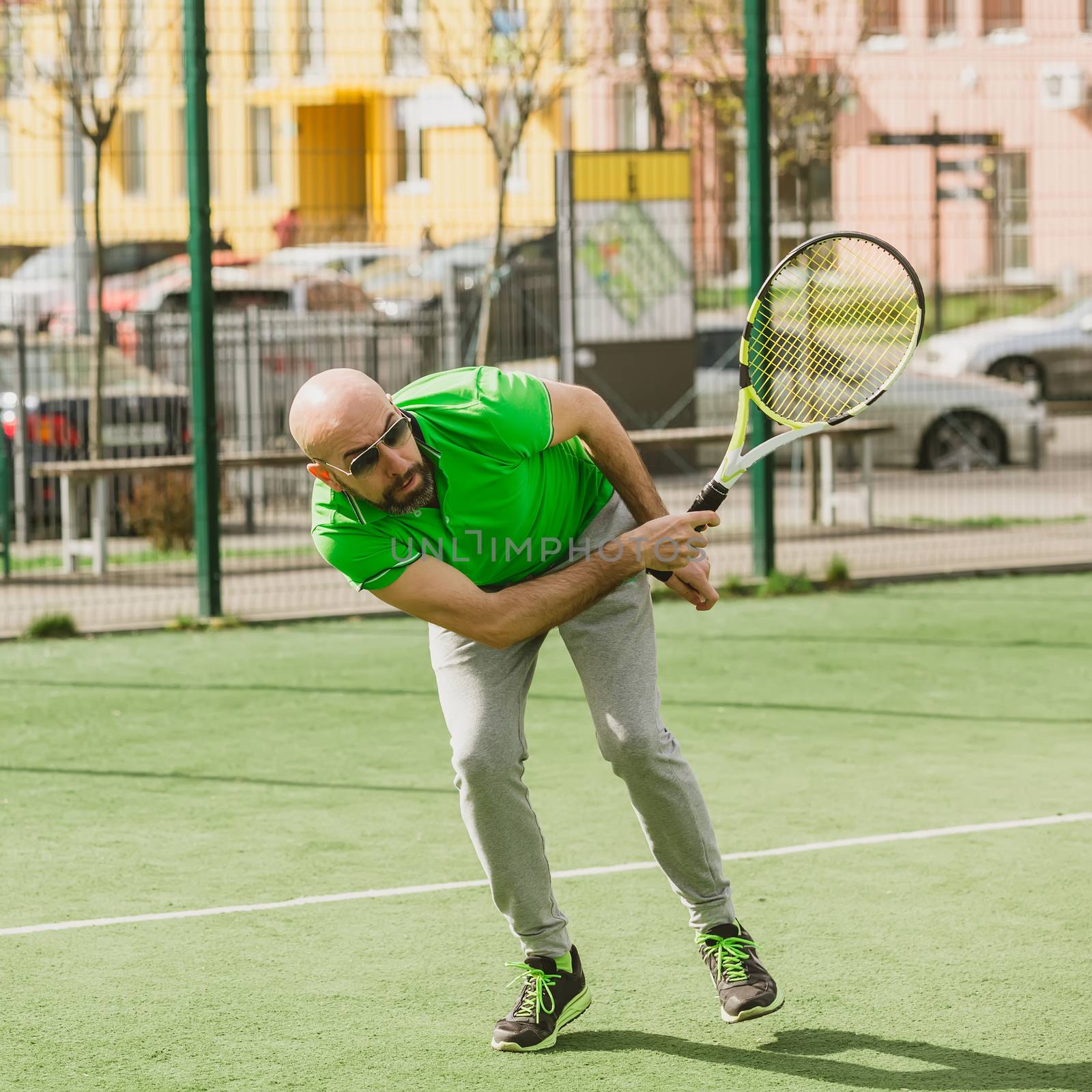 young man play tennis outdoor on tennis field at early morning