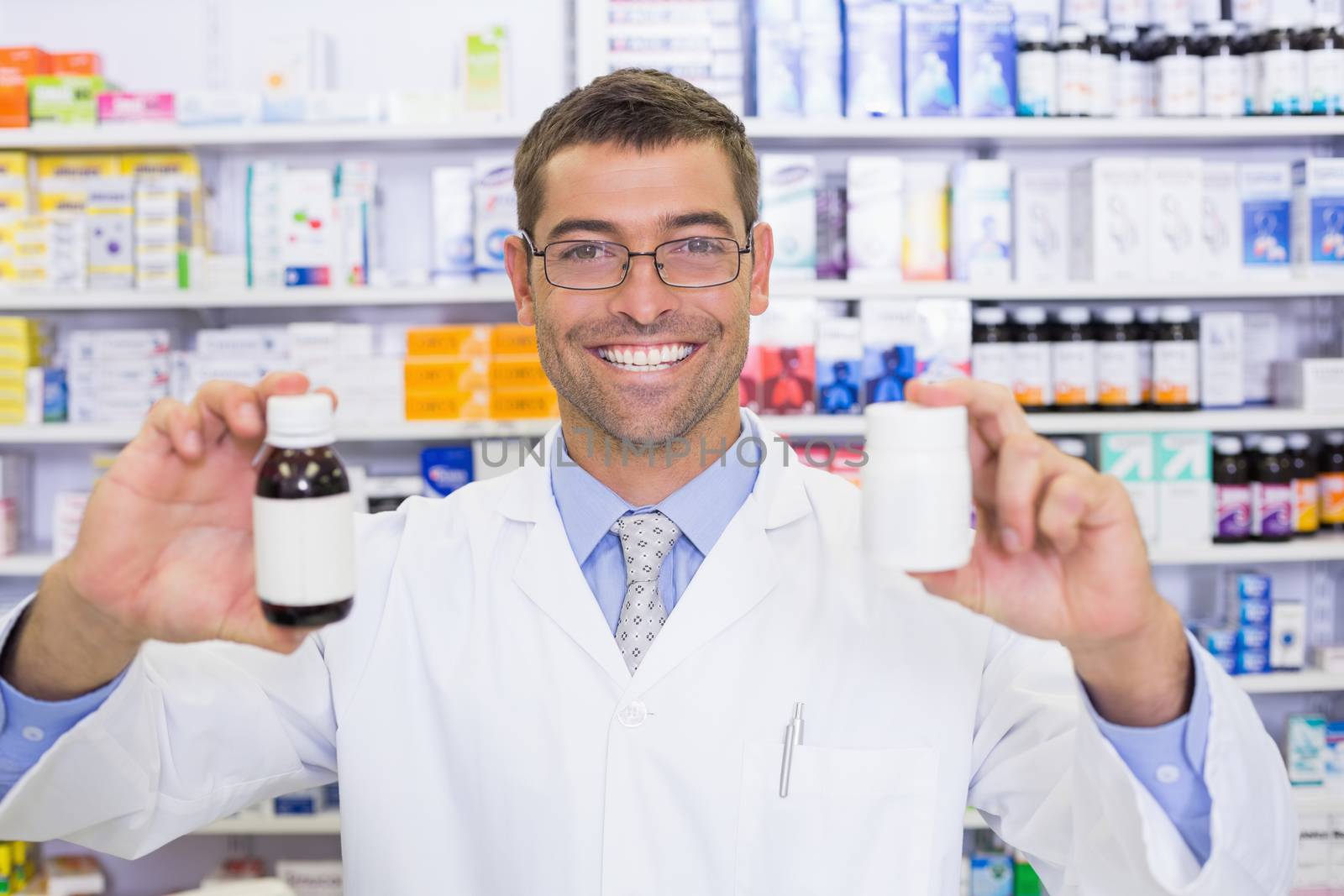 Pharmacist showing medicines jar by Wavebreakmedia