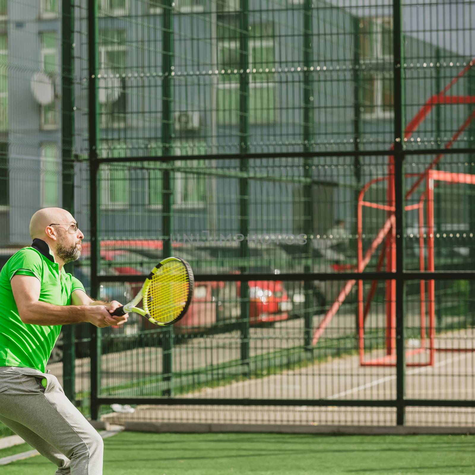 young man play tennis outdoor on tennis field at early morning