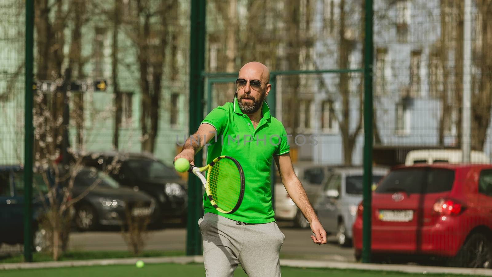 young man play tennis outdoor on tennis field at early morning