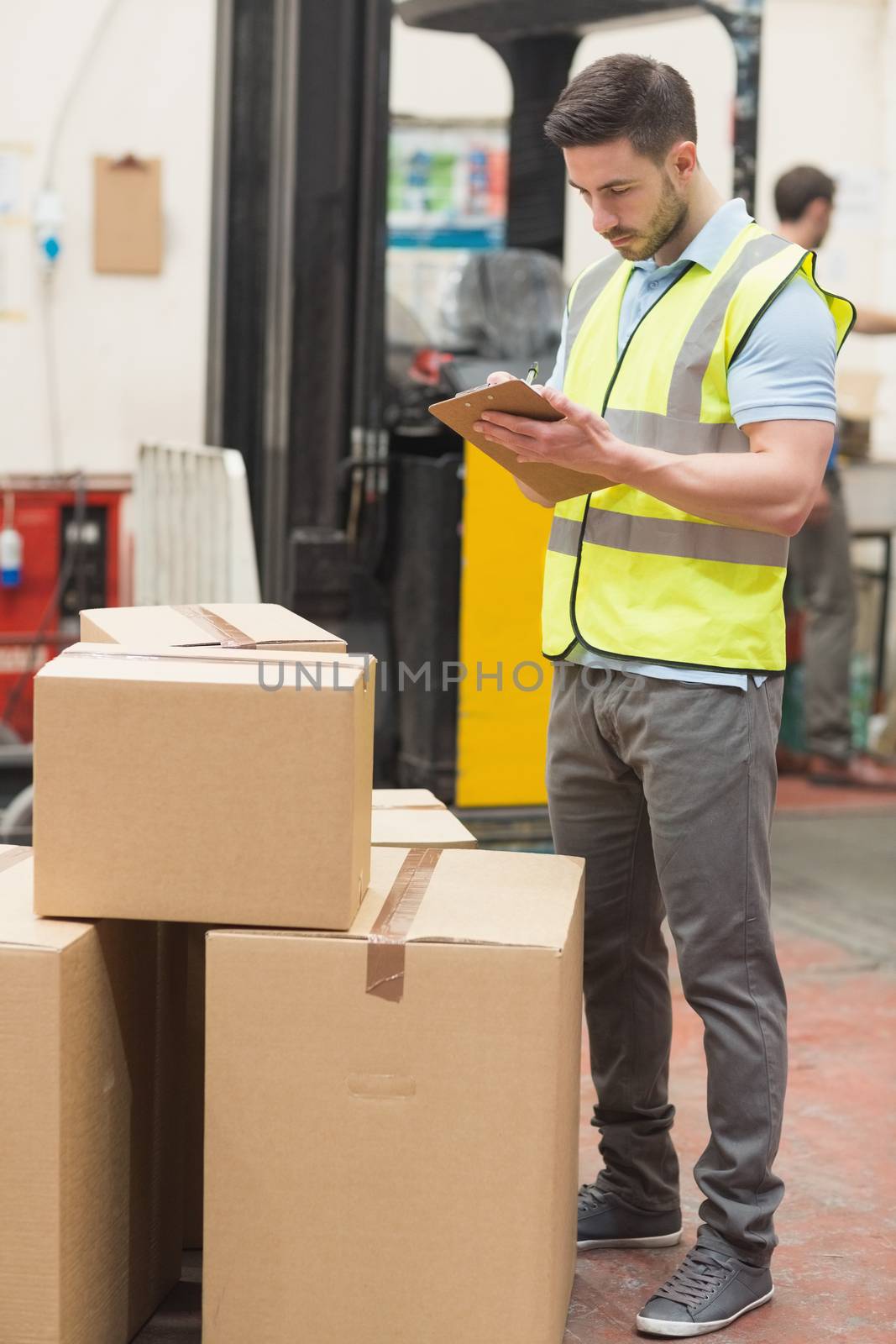 Warehouse worker with clipboard by Wavebreakmedia