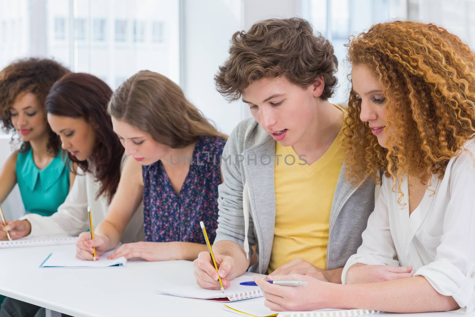 Fashion students taking notes in class by Wavebreakmedia