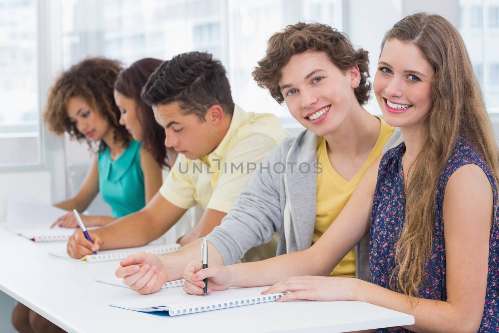 Fashion students taking notes in class by Wavebreakmedia