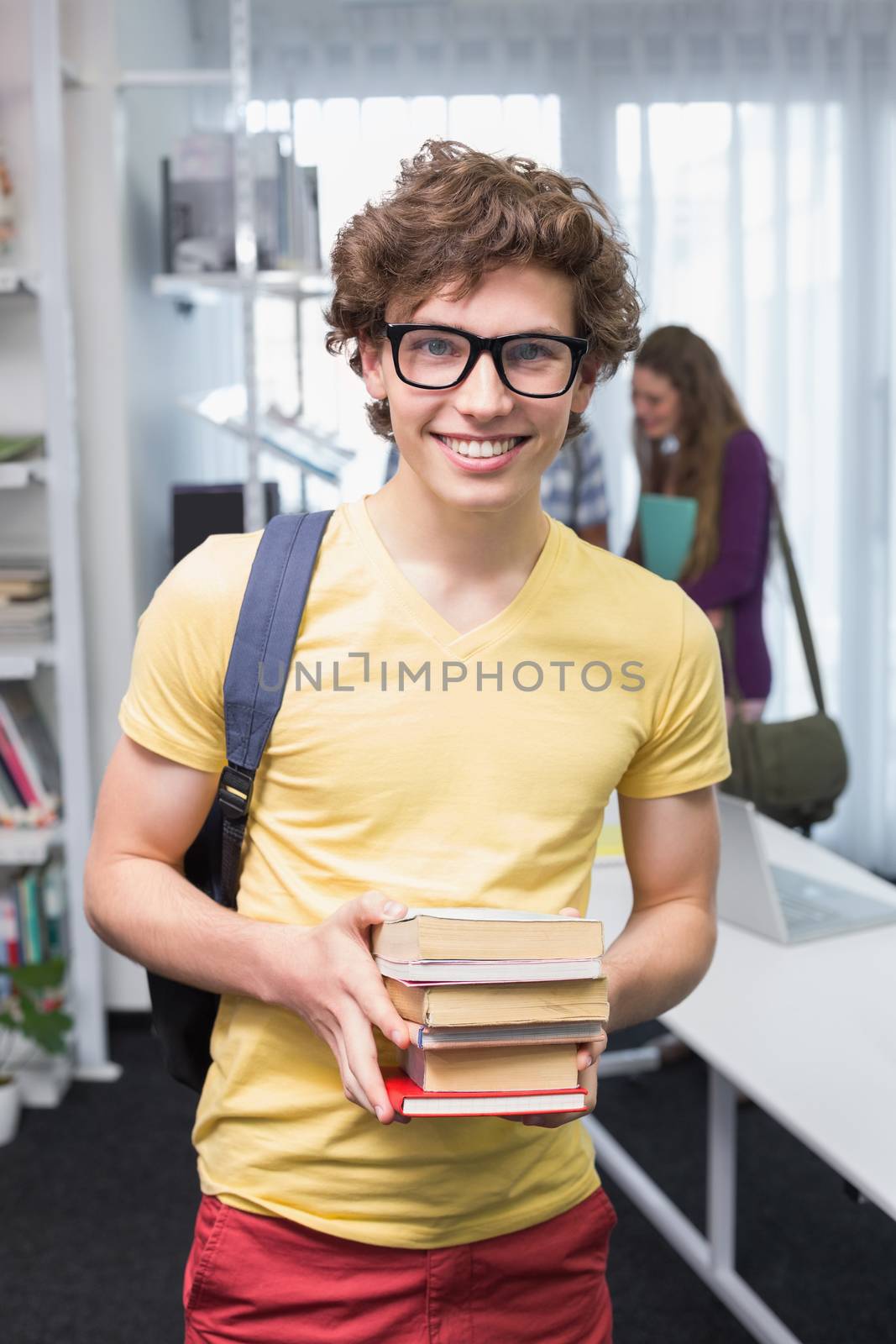 Student carrying small pile of books by Wavebreakmedia