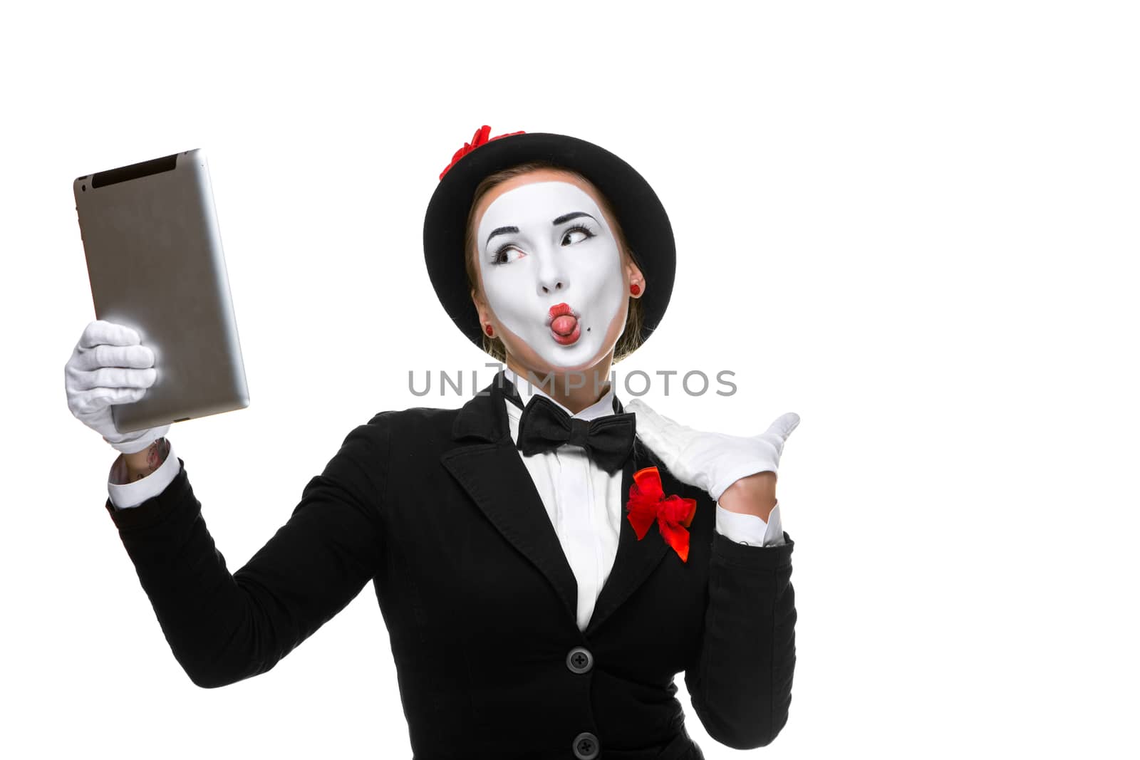 business woman in the image mime holding tablet PC and  looking at a laptop as a mirror  isolated on white background. concept of concept of narcissism at work