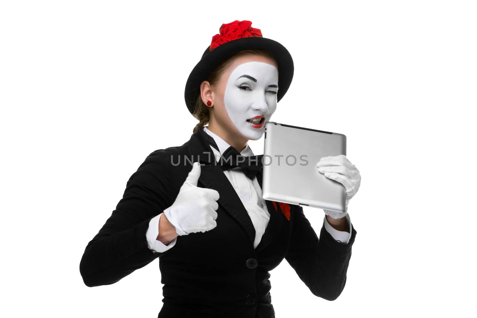 business woman in the image mime holding tablet PC and trying to tooth isolated on white background