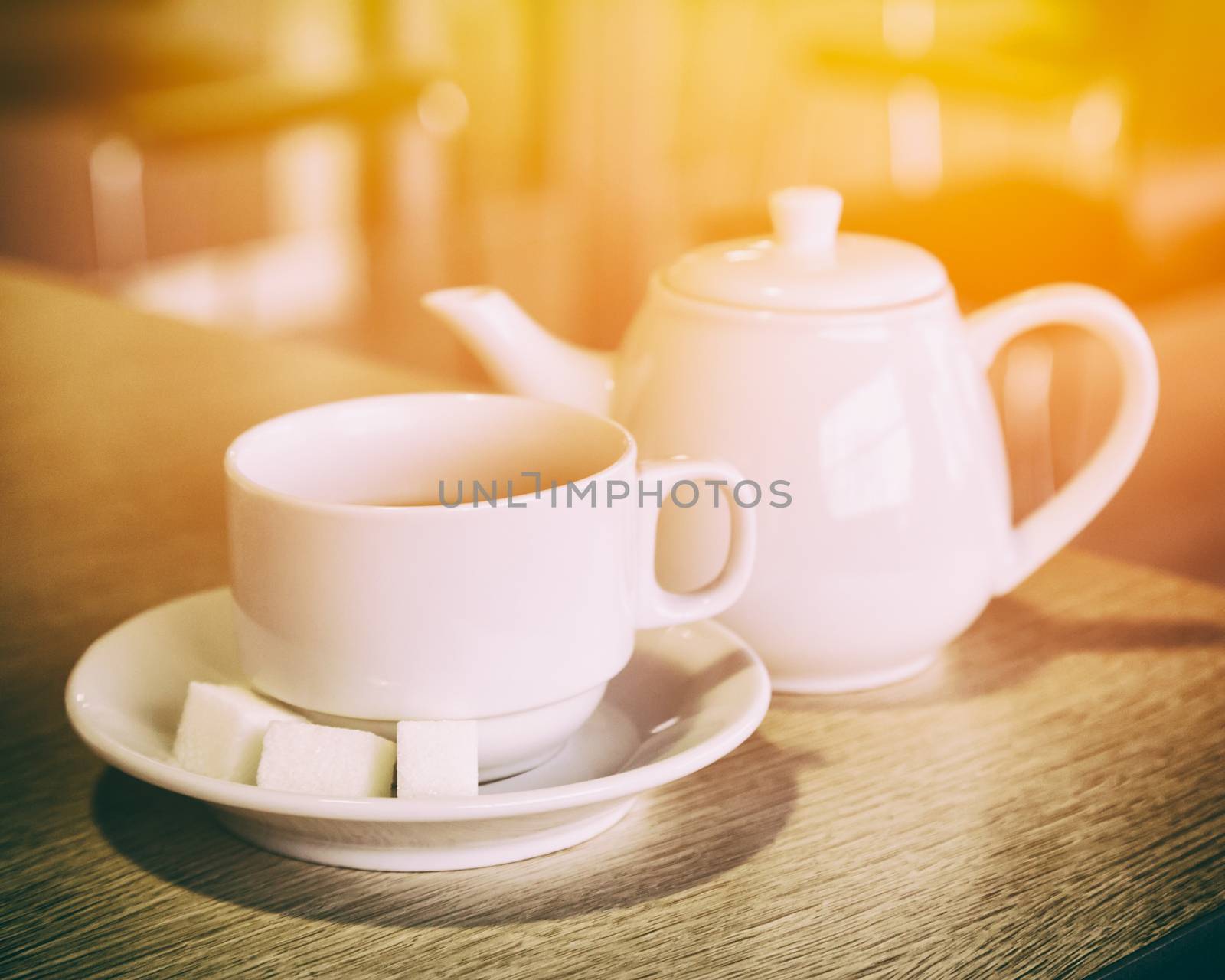 Cup of tea and teapot on the table it the cafe. Shallow depth of field