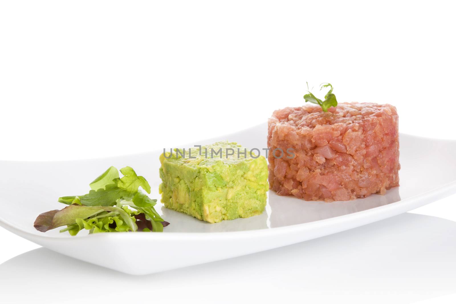 Salmon tartare. Salmon tartare, chopped avocado and fresh salad isolated on white background. Culinary fine eating. 