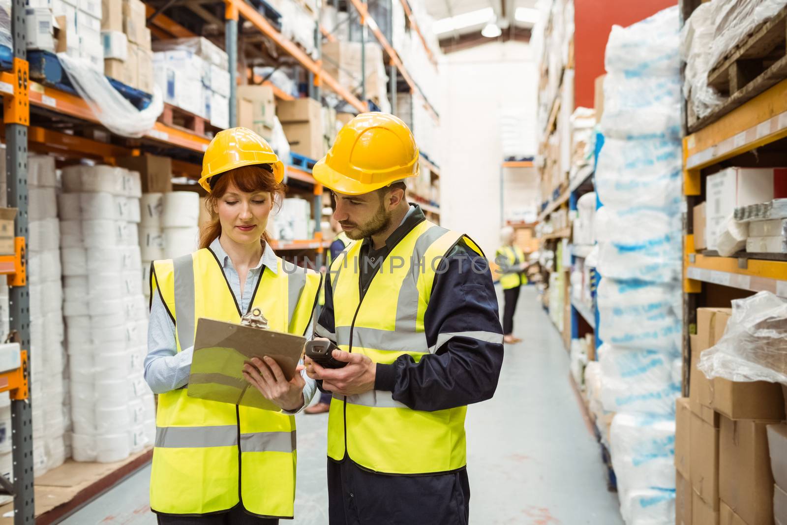 Warehouse manager talking with worker in a large warehouse