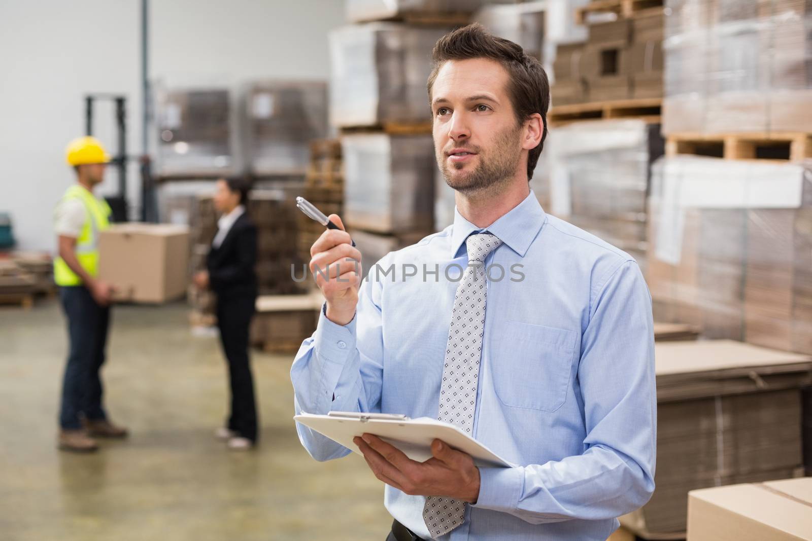 Warehouse manager checking his inventory by Wavebreakmedia
