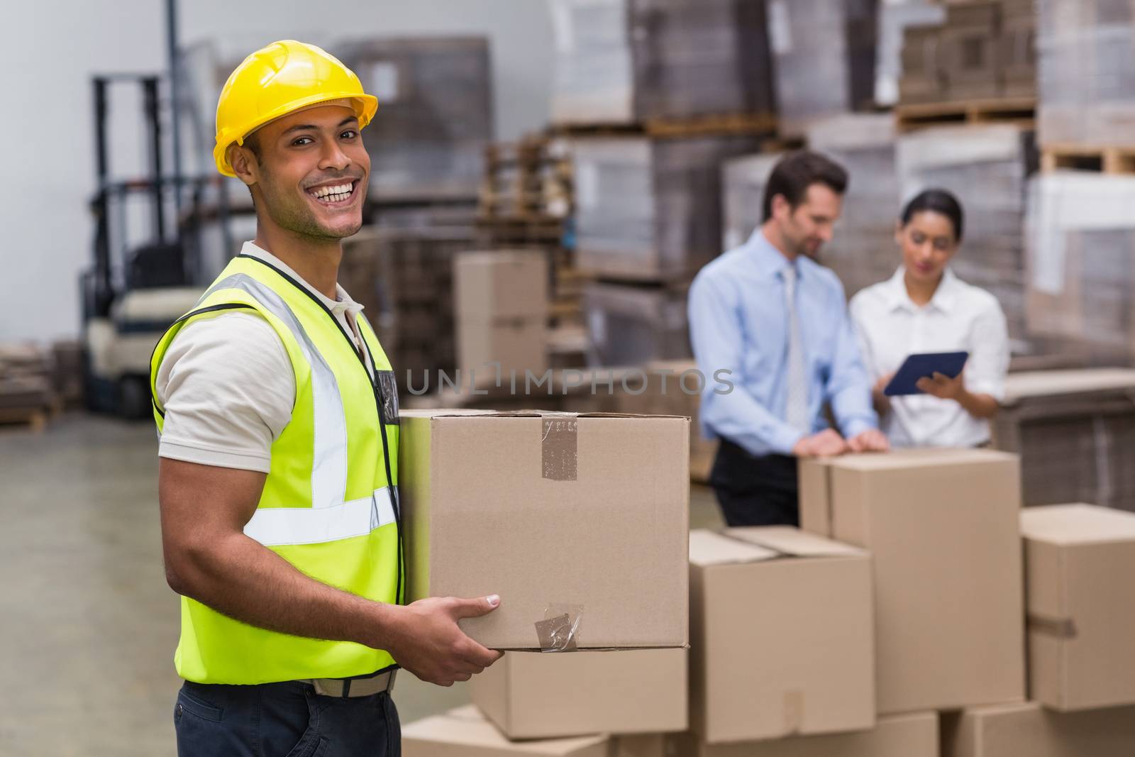 Portrait of worker carrying box in the warehouse