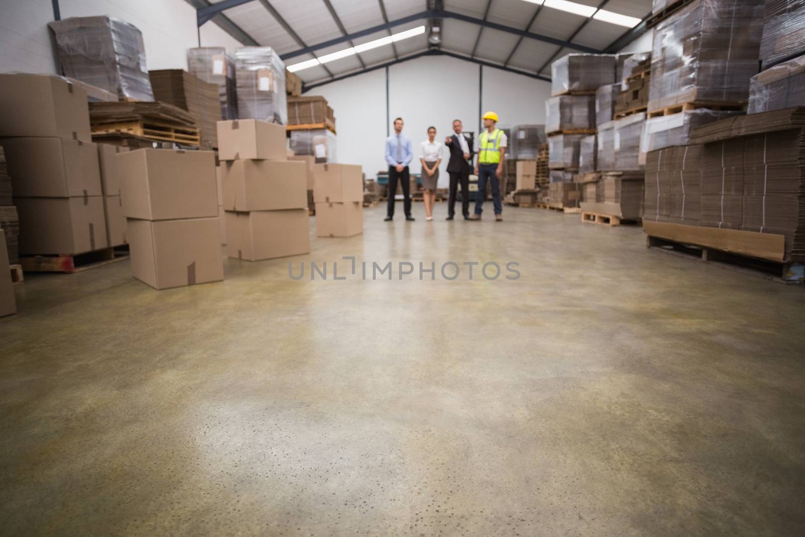 Warehouse managers and worker talking together by Wavebreakmedia