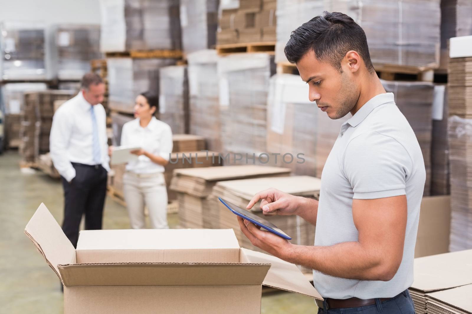 Manager using digital tablet in warehouse by Wavebreakmedia