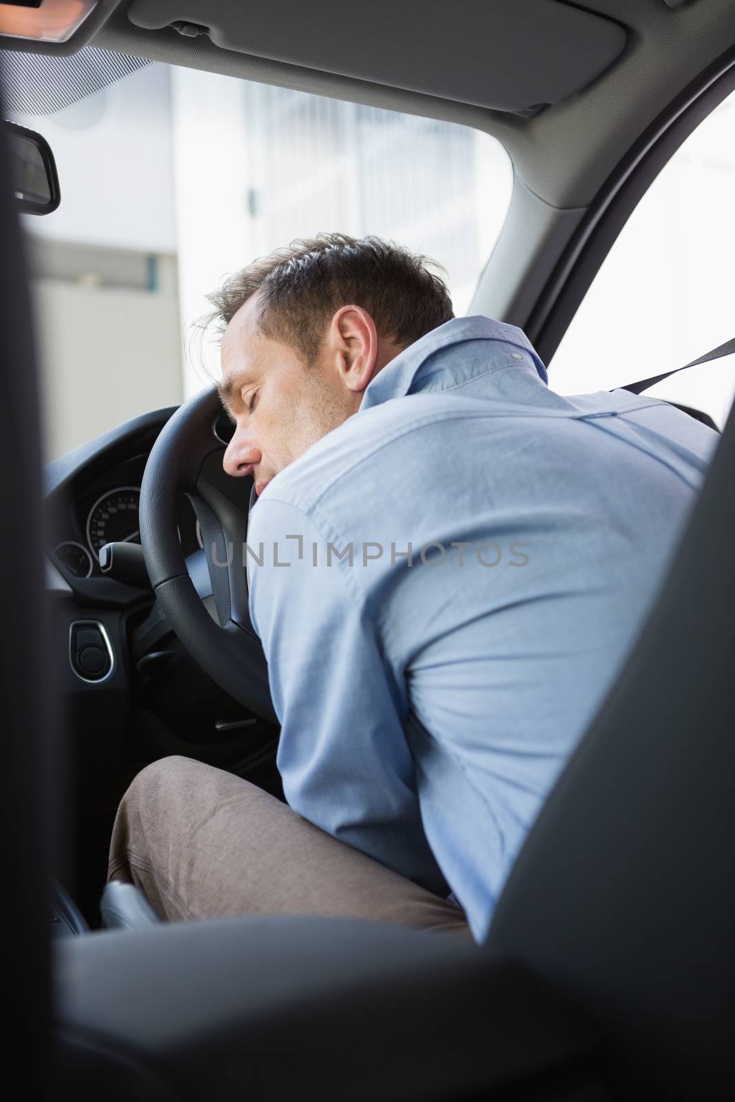 Drunk man slumped on steering wheel by Wavebreakmedia