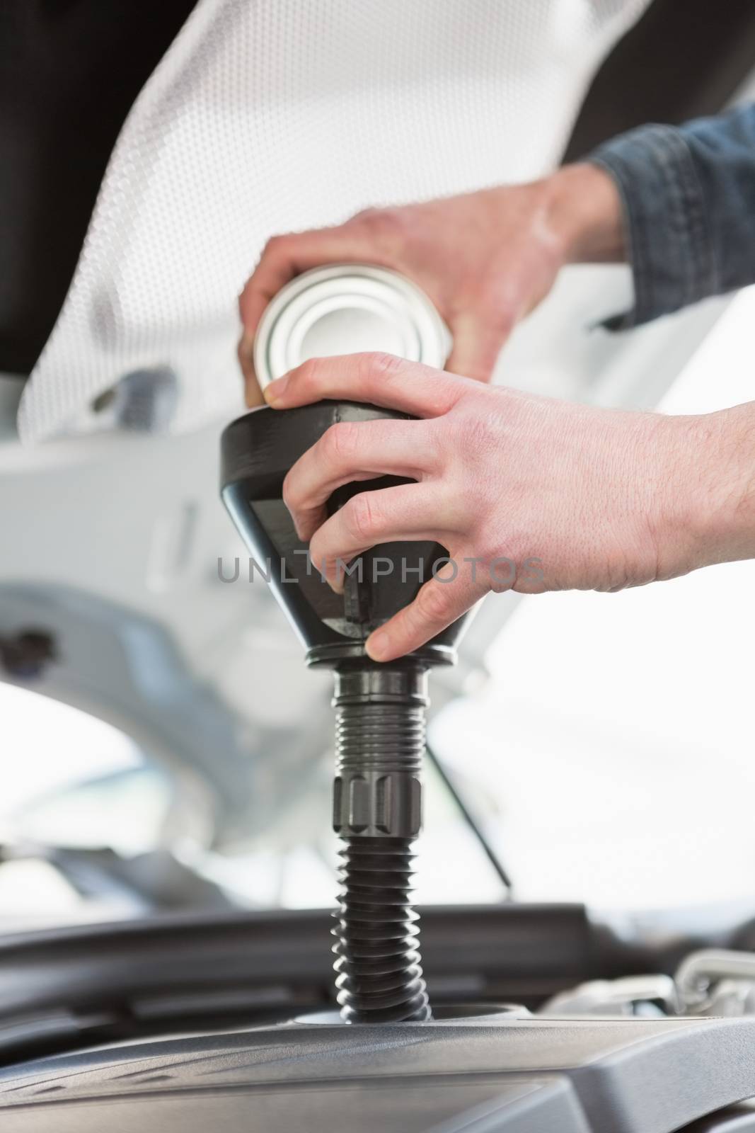 Man pouring oil into engine of his car