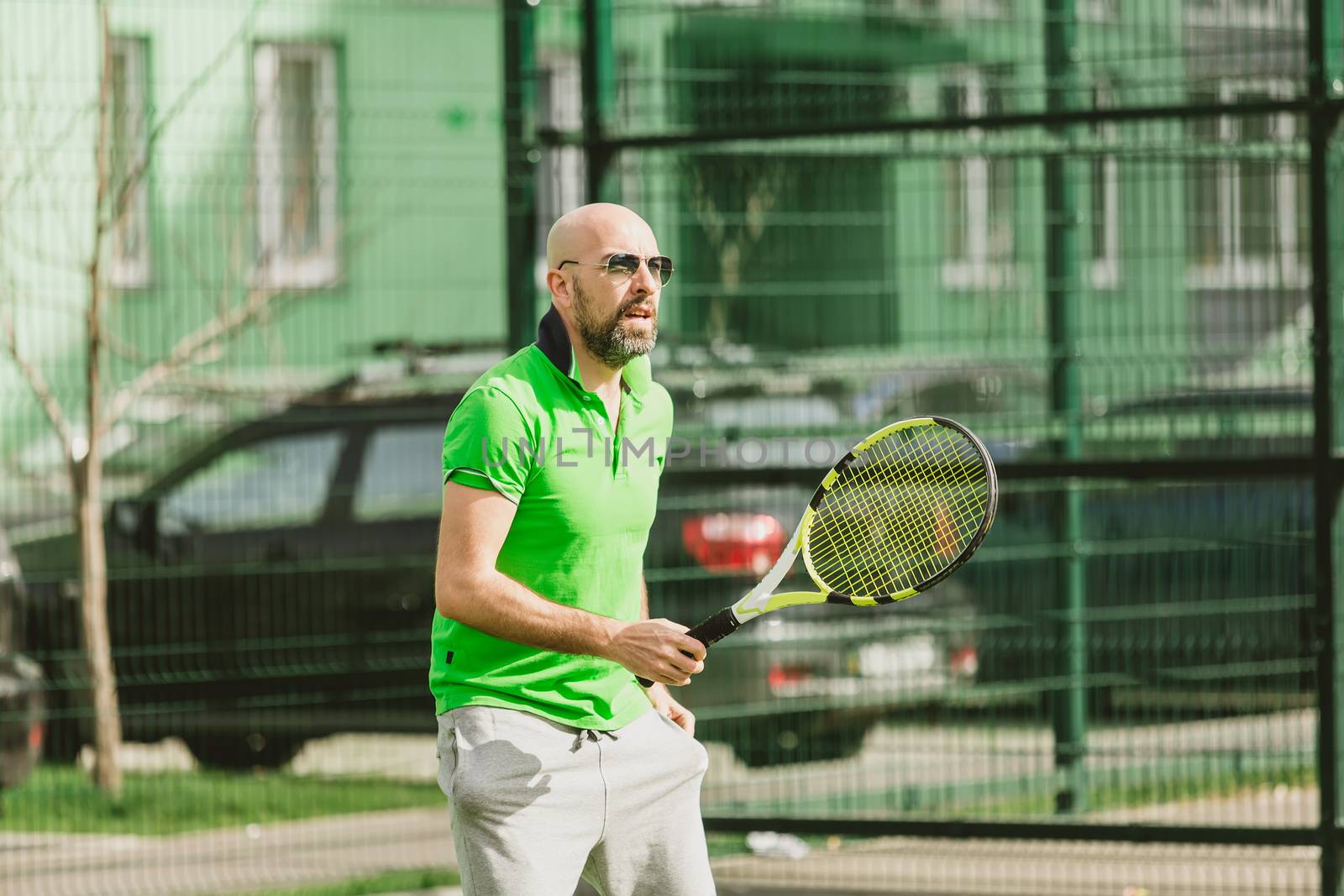 young man play tennis outdoor on tennis field at early morning