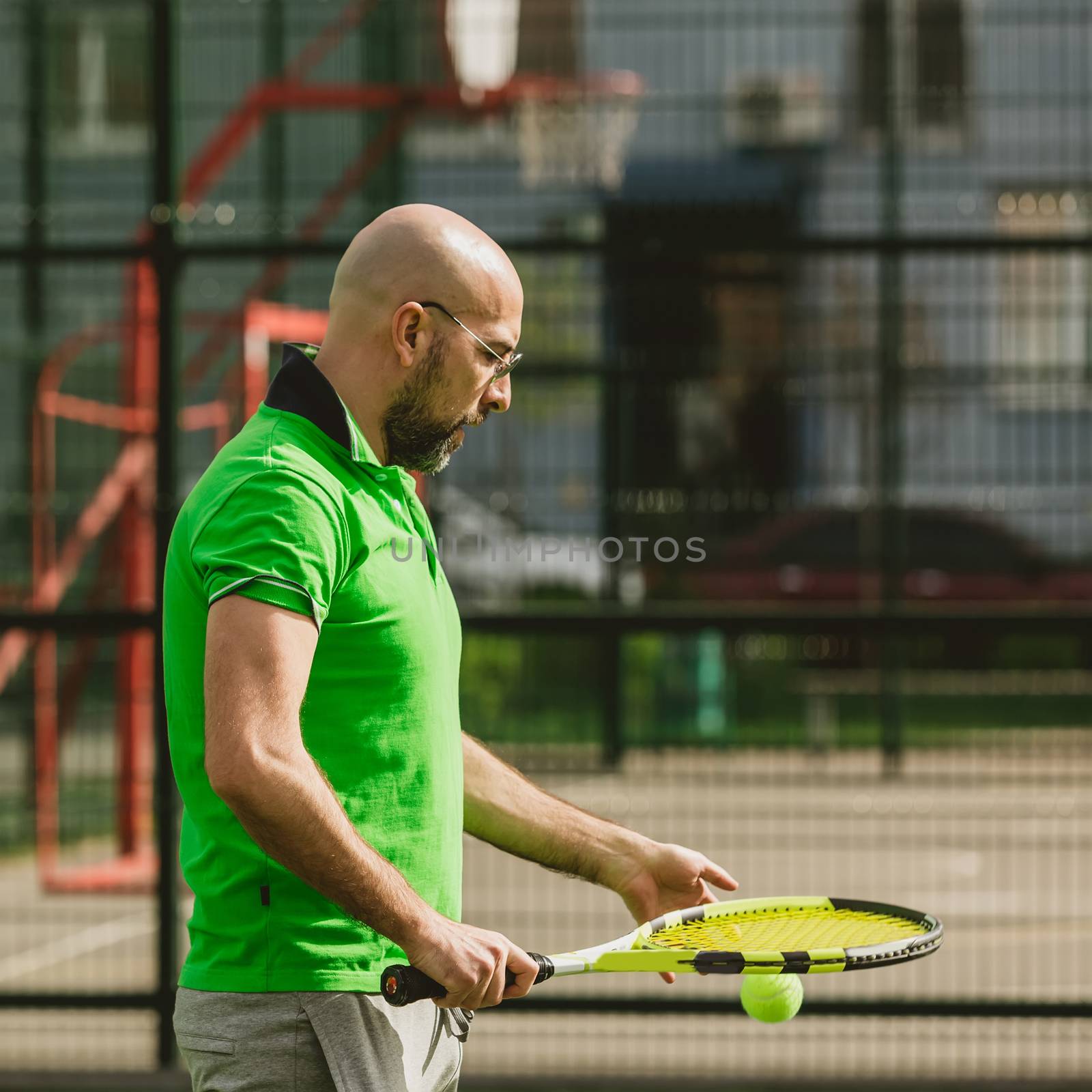 young man play tennis outdoor on tennis field at early morning