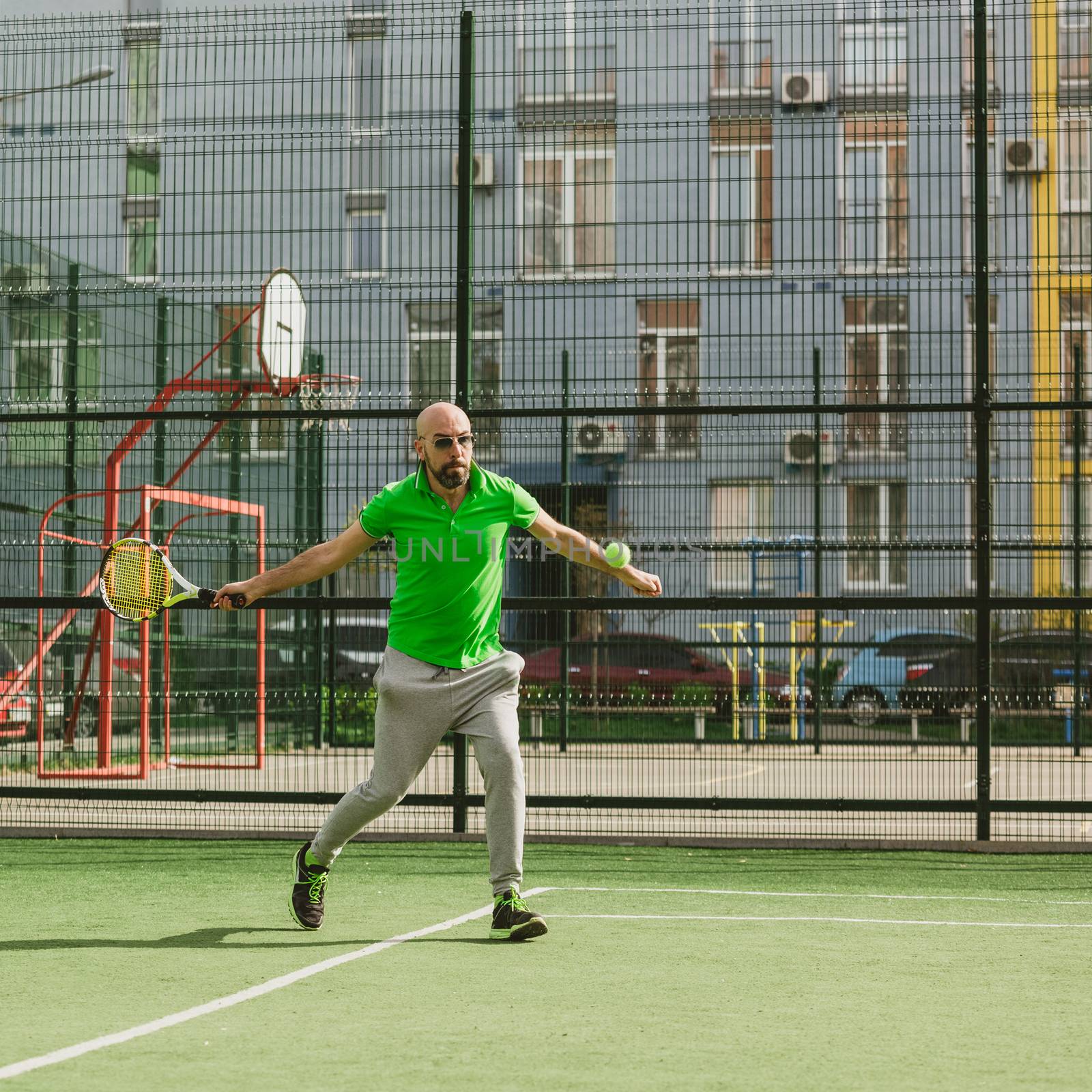 young man play tennis outdoor on tennis field at early morning