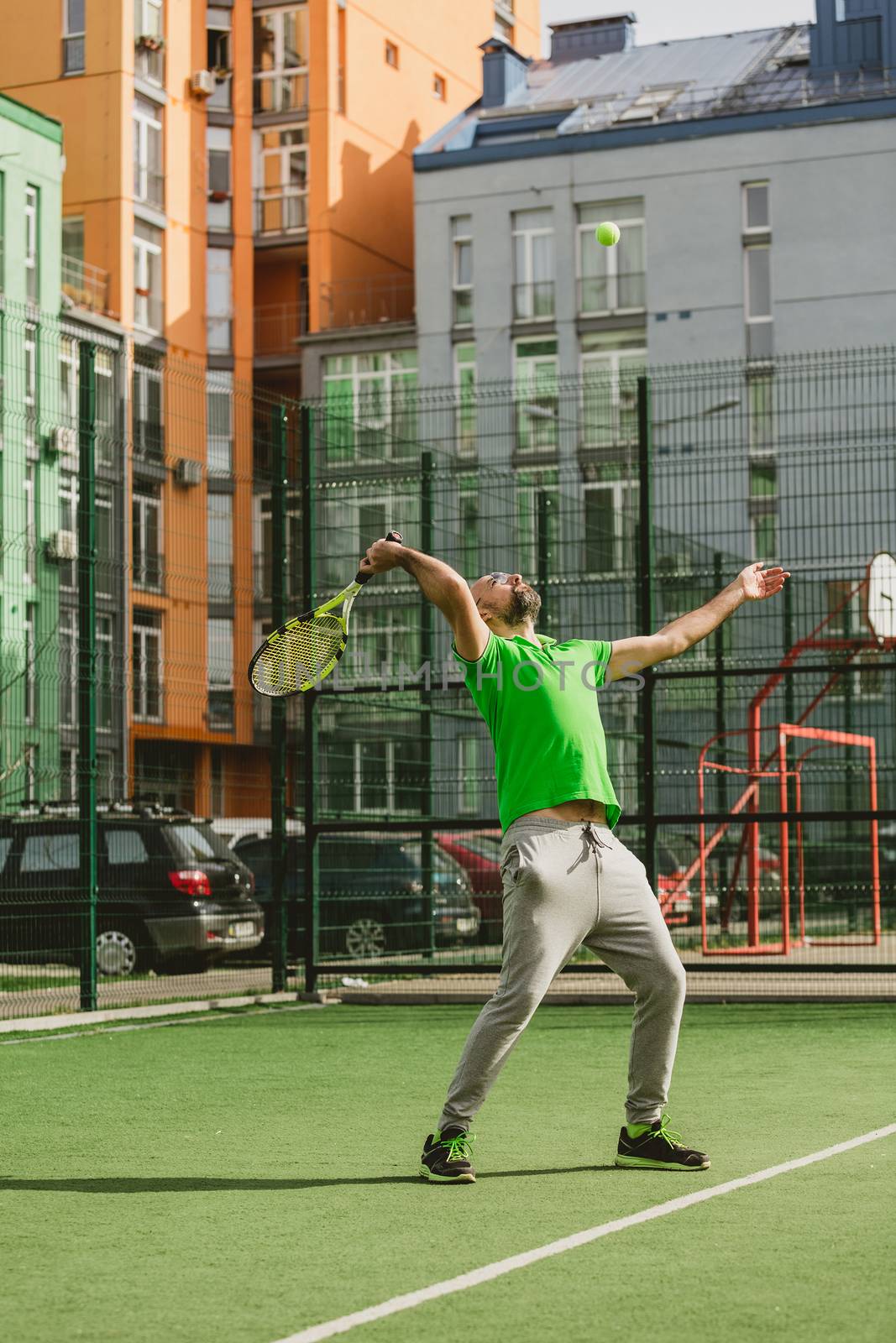 young man play tennis outdoor on tennis field at early morning