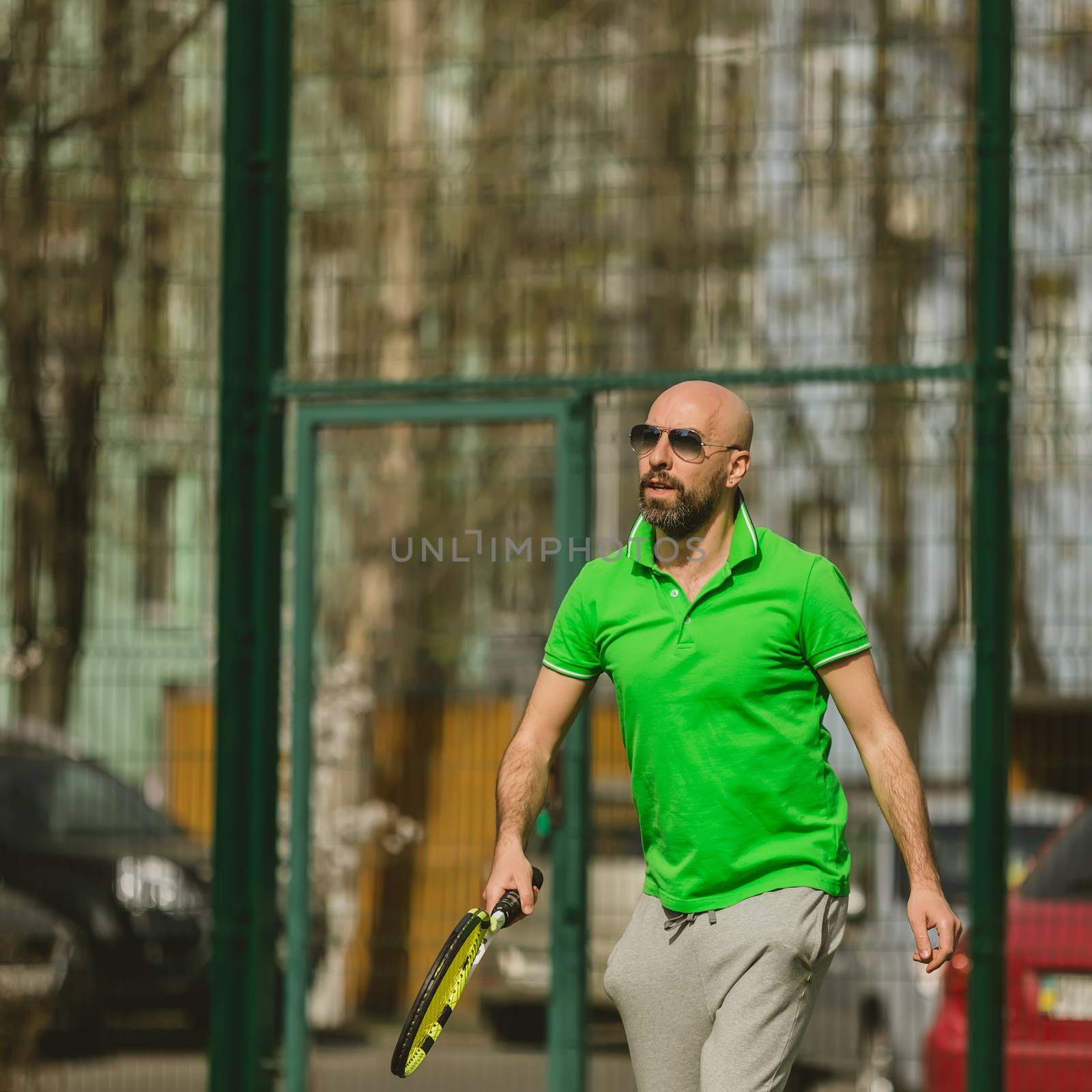 young man play tennis outdoor on tennis field at early morning