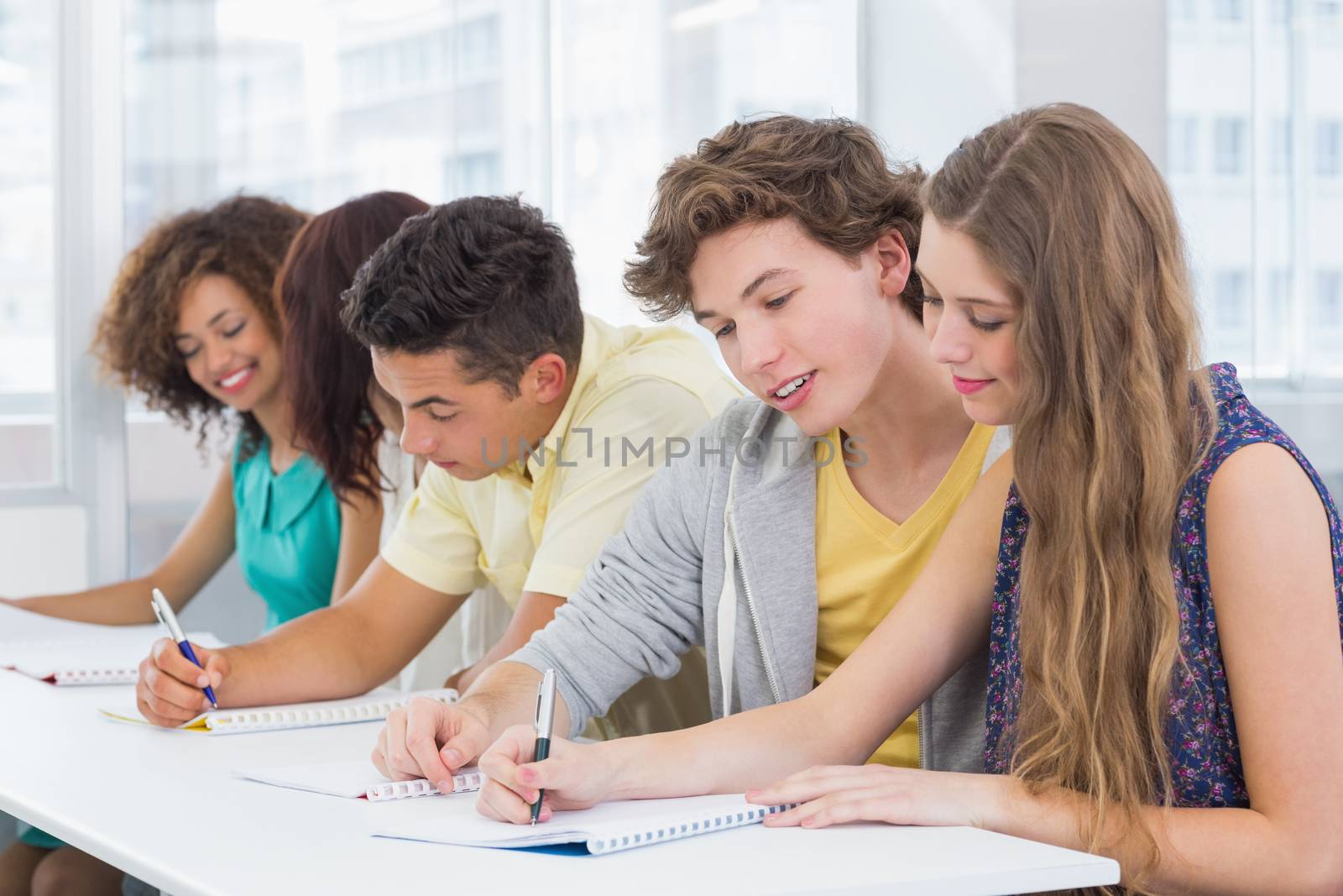 Fashion students taking notes in class by Wavebreakmedia