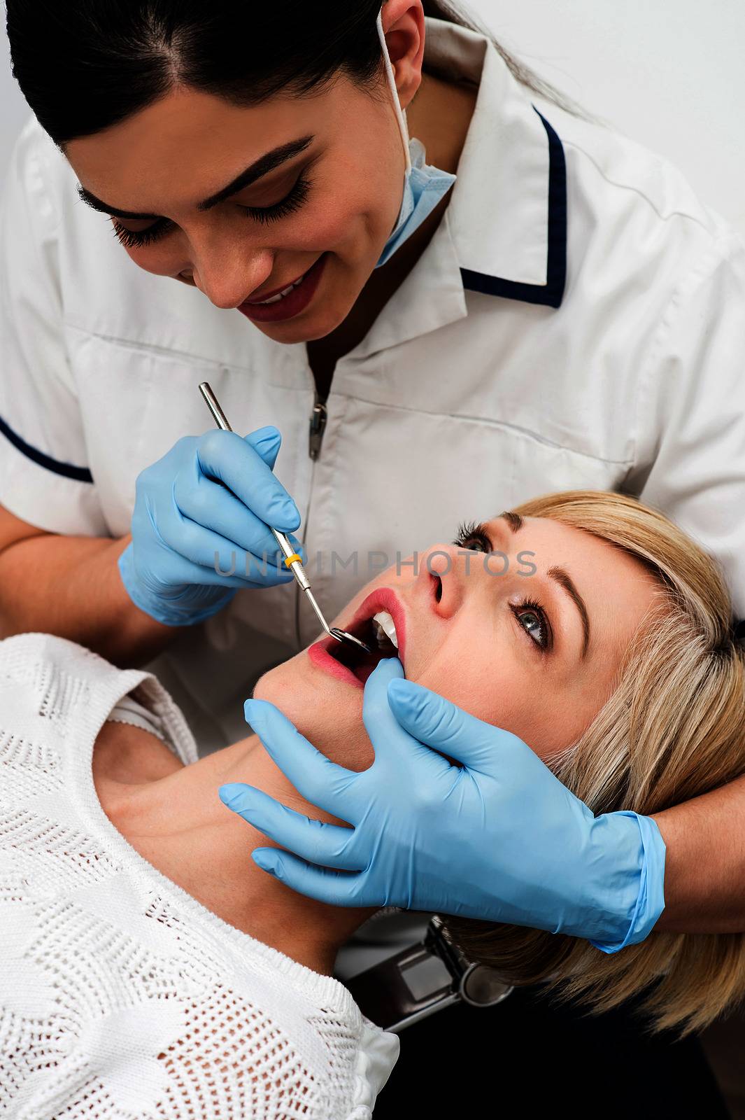 Female patient teeth checked by dentist