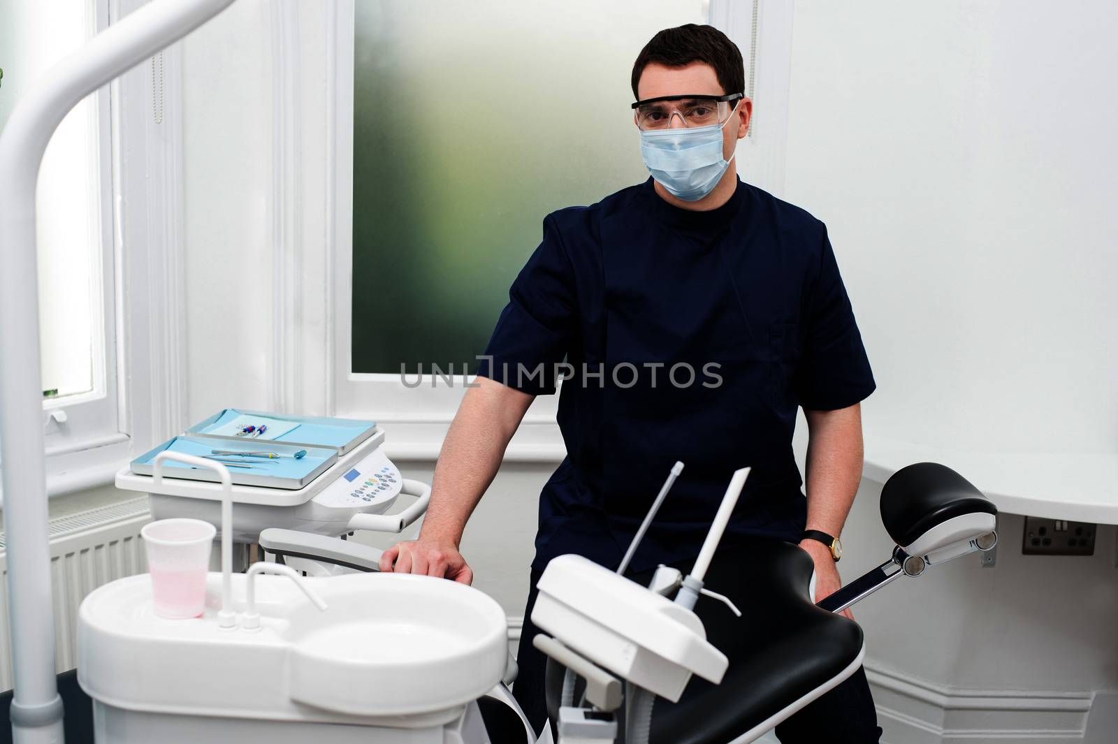 Male dental assistant standing beside chair