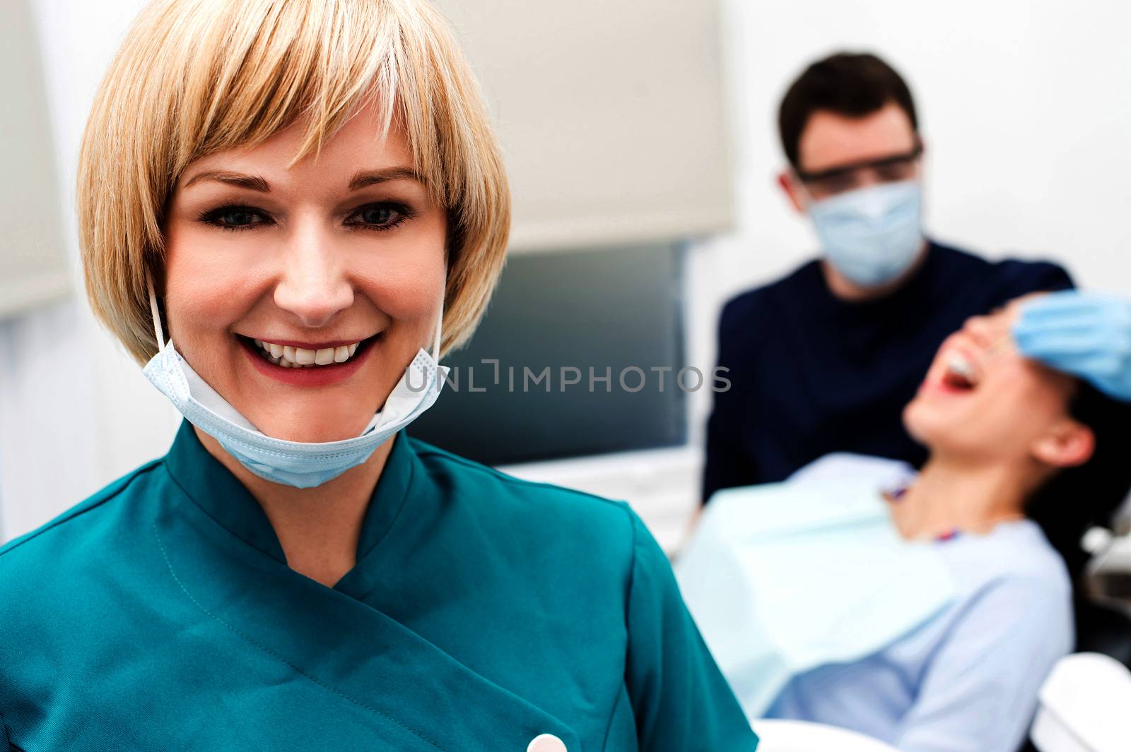 Male dentist doing teeth checkup behind by stockyimages