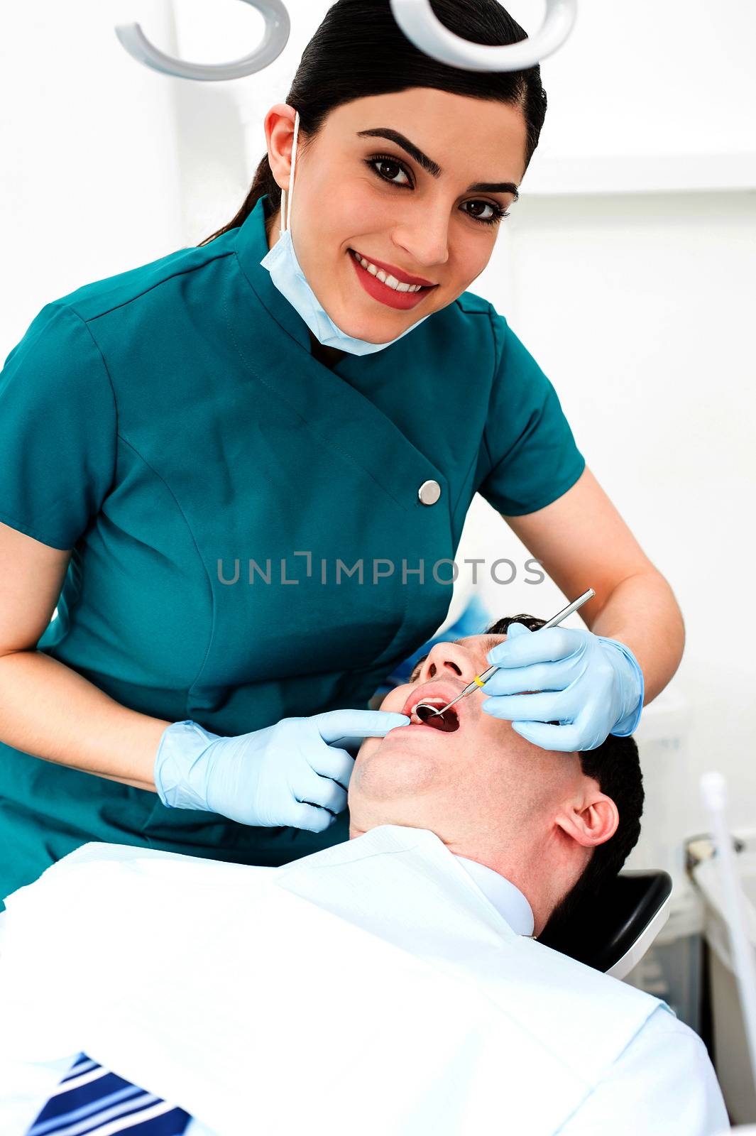 Female dentist examines a patient by stockyimages