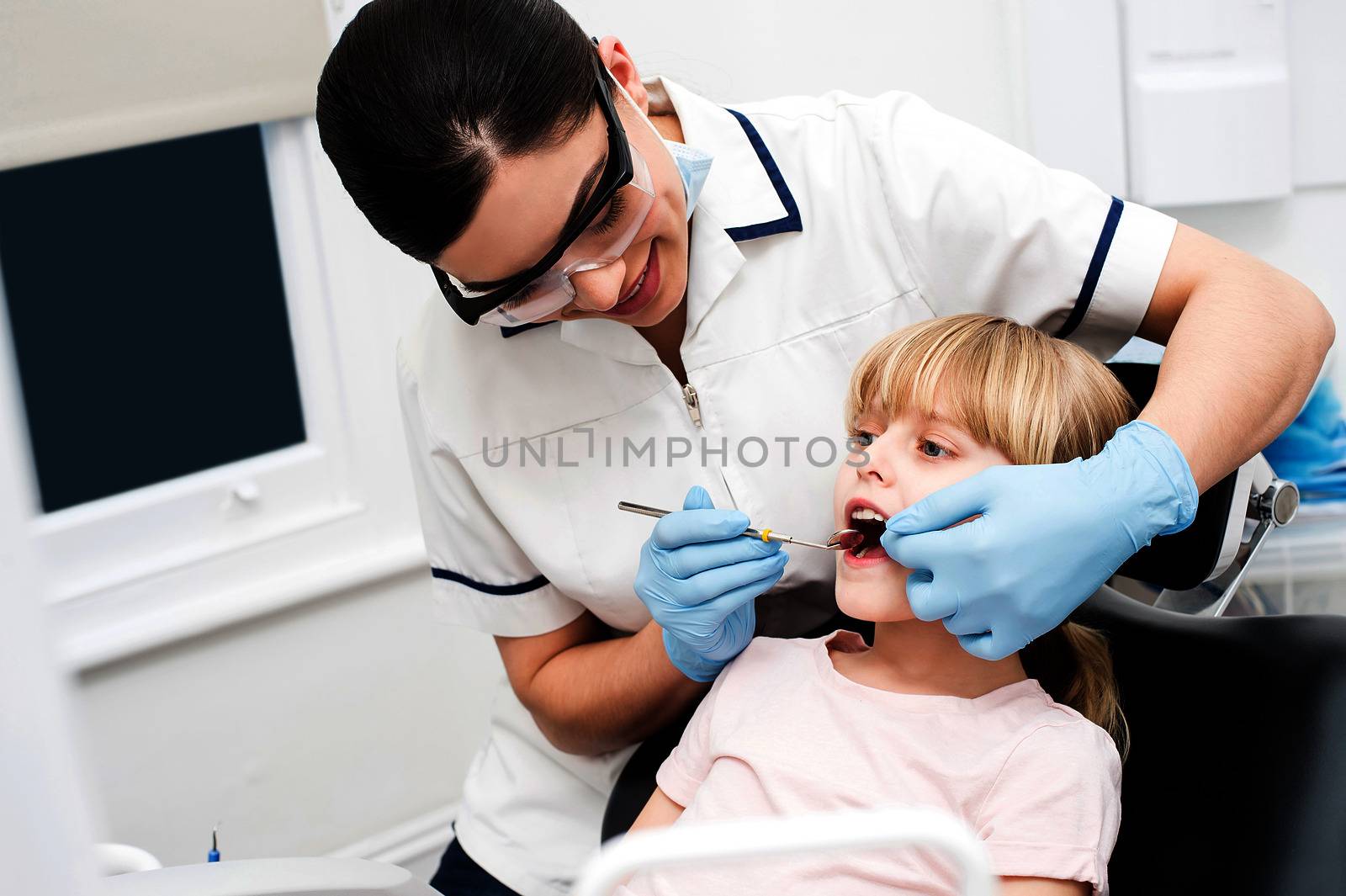 Little girl at dental clinic. by stockyimages