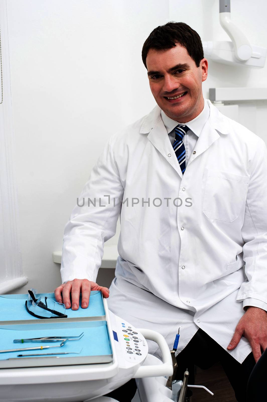 Friendly male dentist smiling at dental clinic