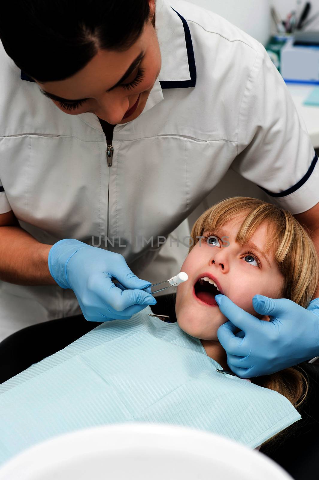 Dental assistant examine a little girl 