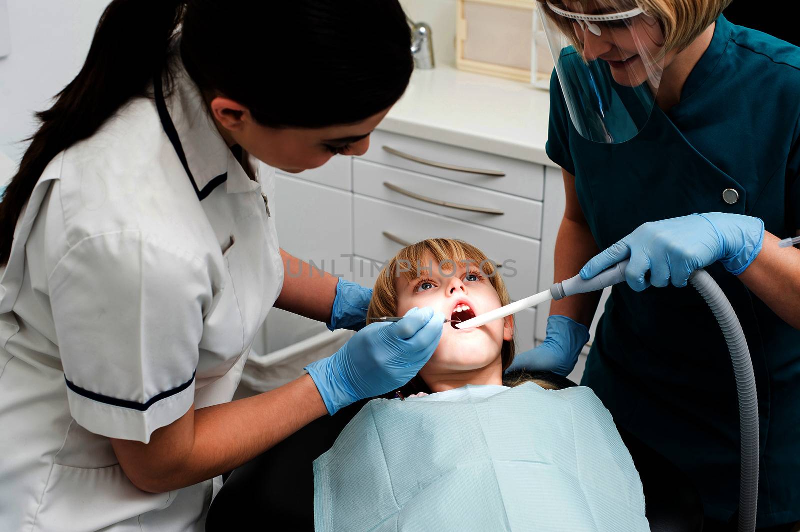 Female dentist treat child patient by stockyimages