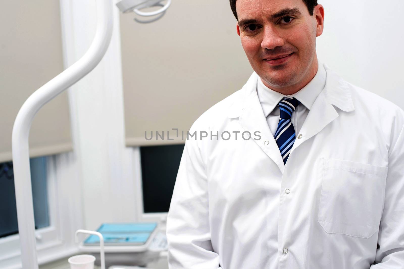 Dentist in his modern clinic. by stockyimages