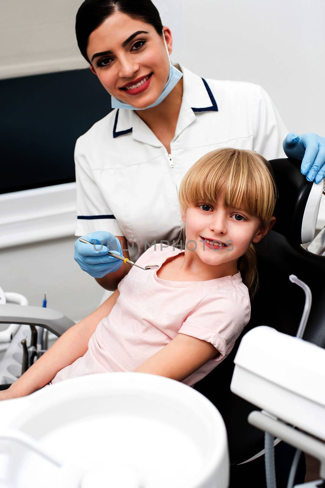 Dental assistant and little girl looking at camera
