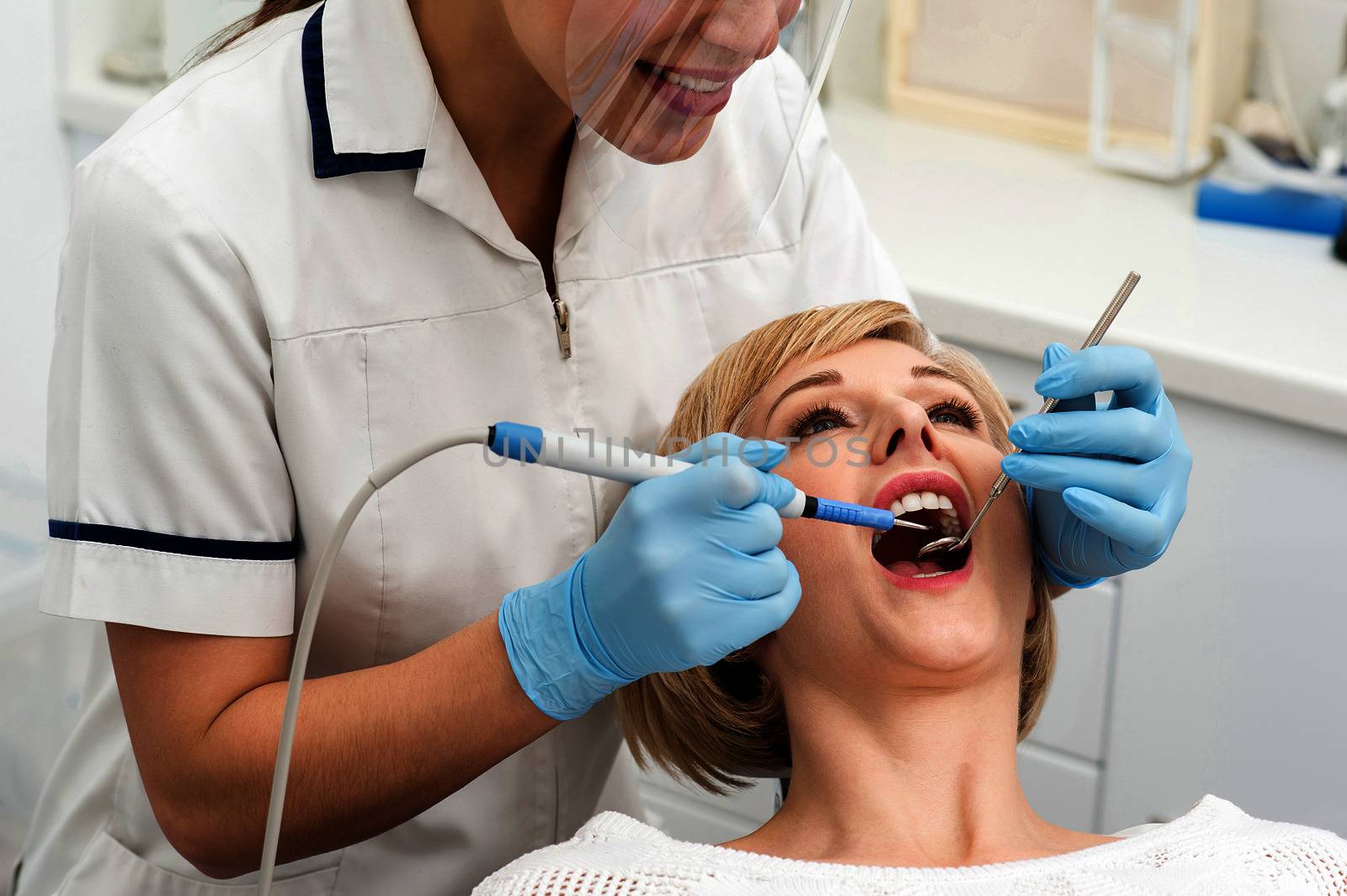 Female dentist procedure of teeth cleaning