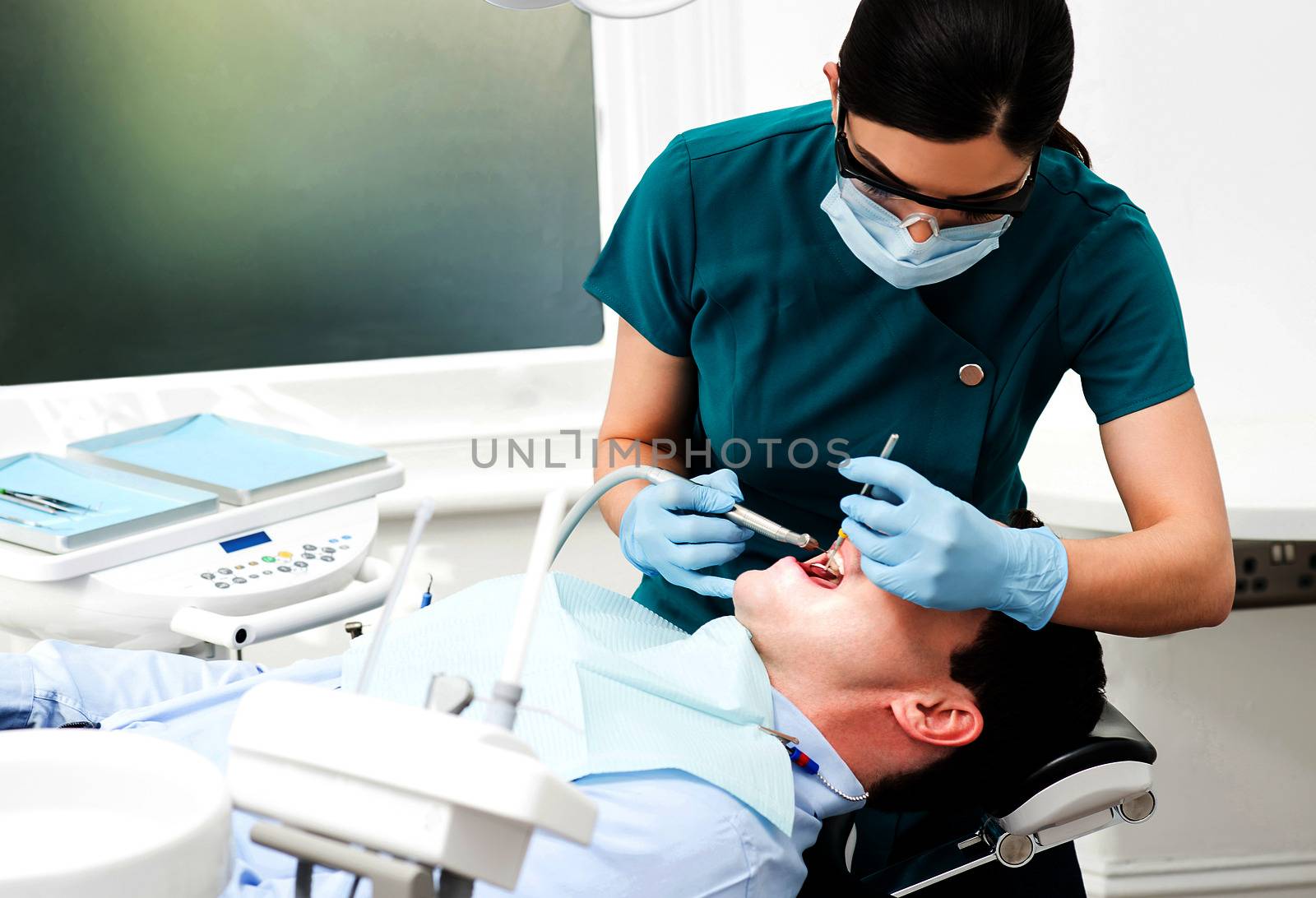 Female dentist treat male patient in clinic