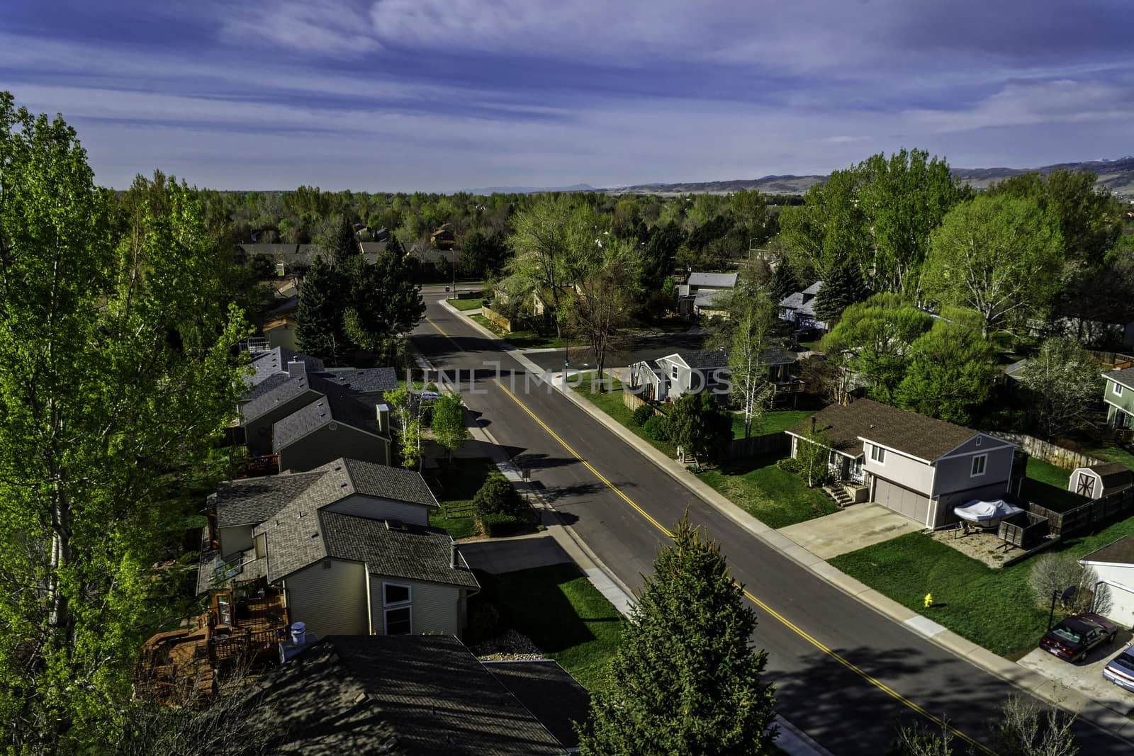 FORT COLLINS, CO, USA - APRIL 25, 2015: Aerial view of a street in Fort Collins, a typical residential neighborhood along Front Range of Rocky Mountains in Colorado with 30 years old houses,  early spring with green trees