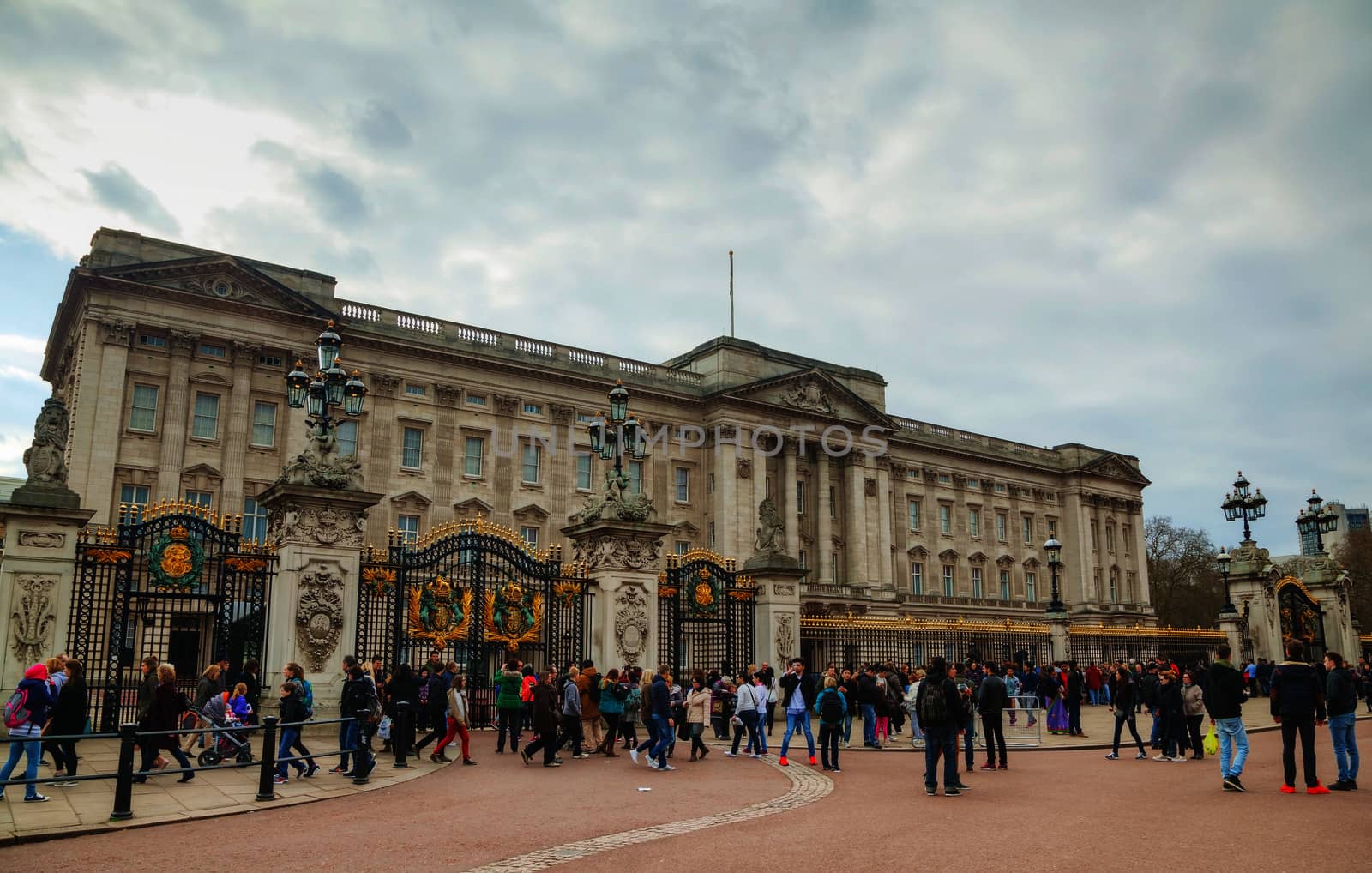 LONDON - APRIL 5: Buckingham palace with tourists on April 5, 2015 in London, UK. It's the London residence and principal workplace of the monarchy of the United Kingdom.