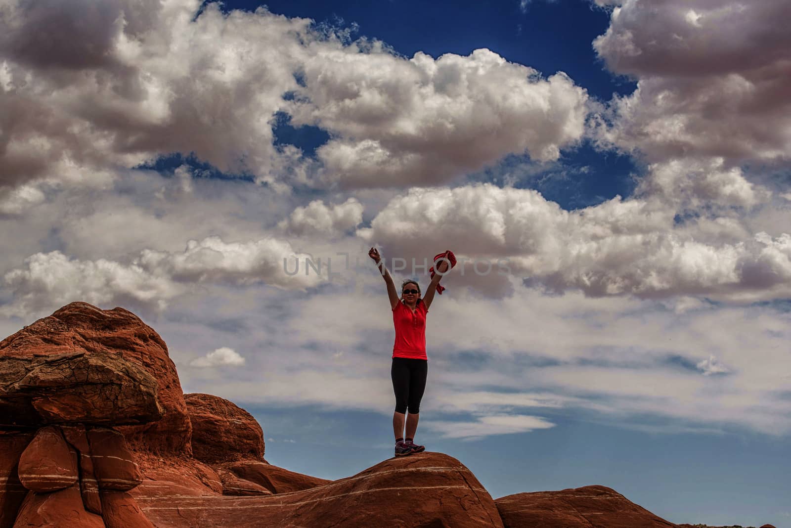 teenage girl with red top on large rock