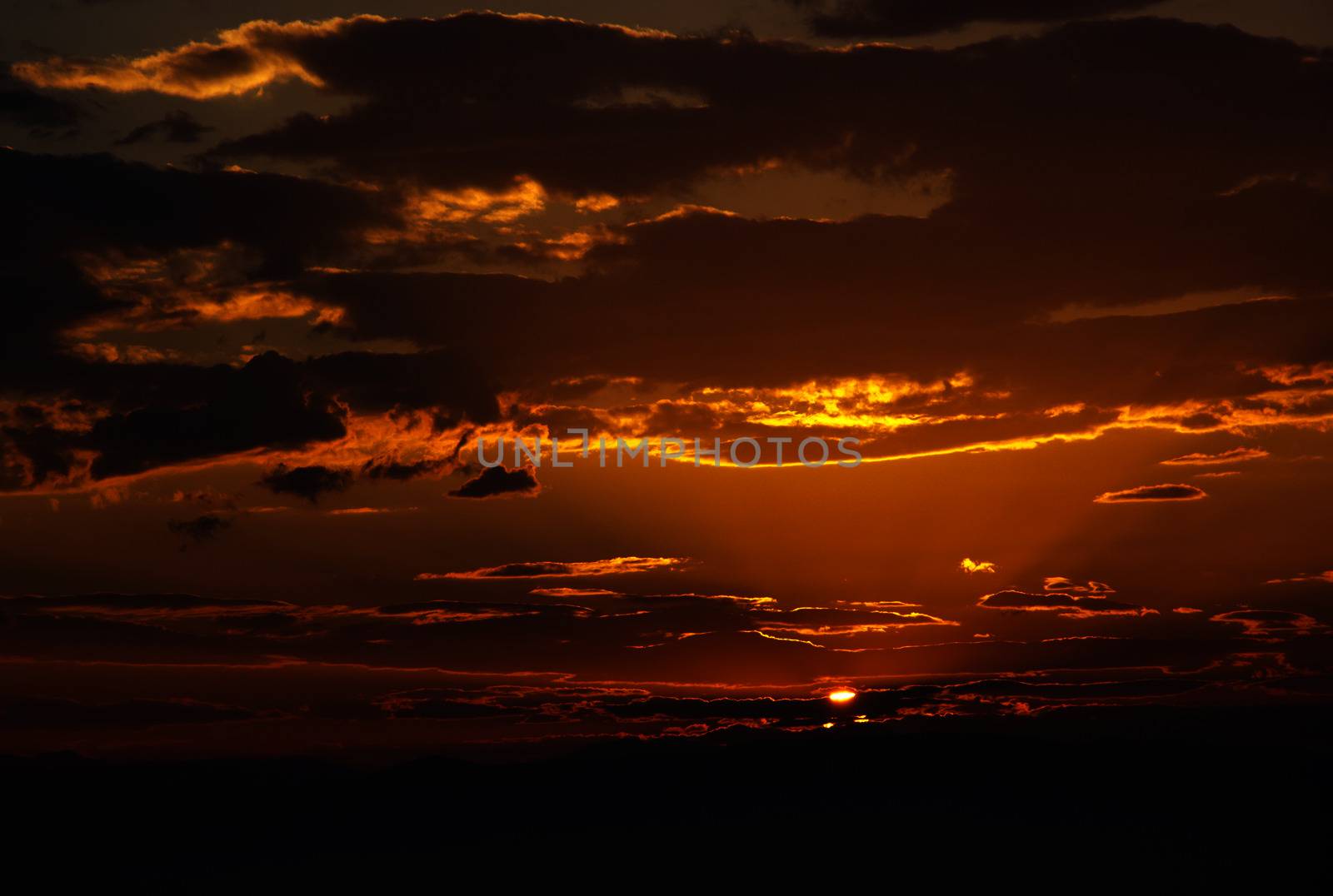 Sunrise in the morning with orange colored clouds over the mountains