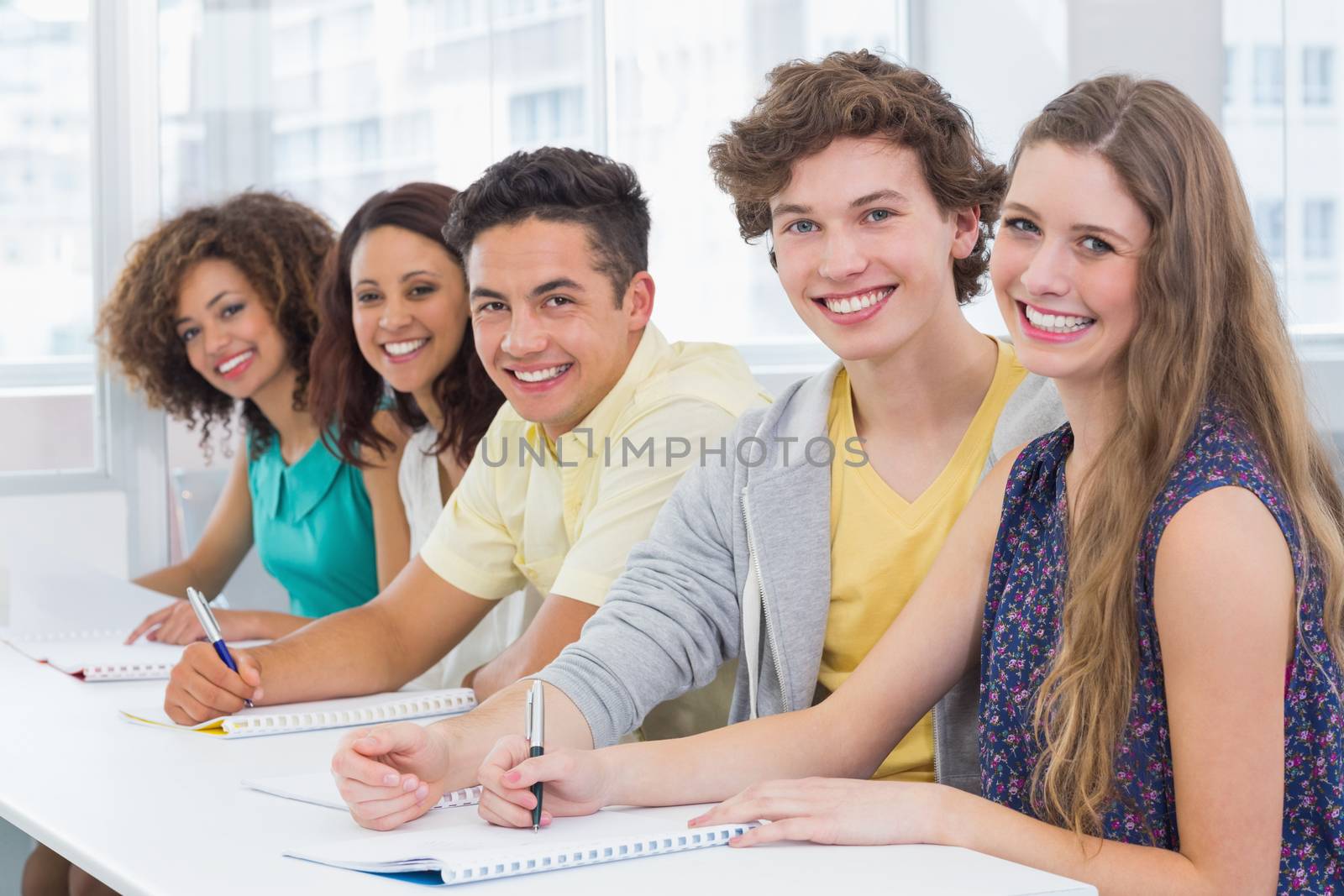 Fashion students taking notes in class by Wavebreakmedia