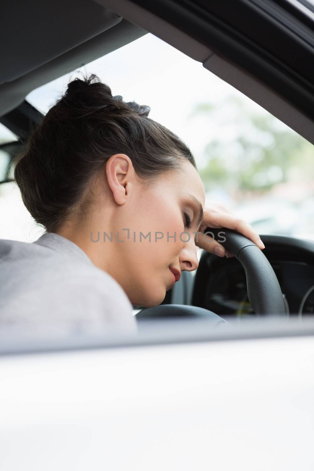 Woman sleeping on the wheel in her car
