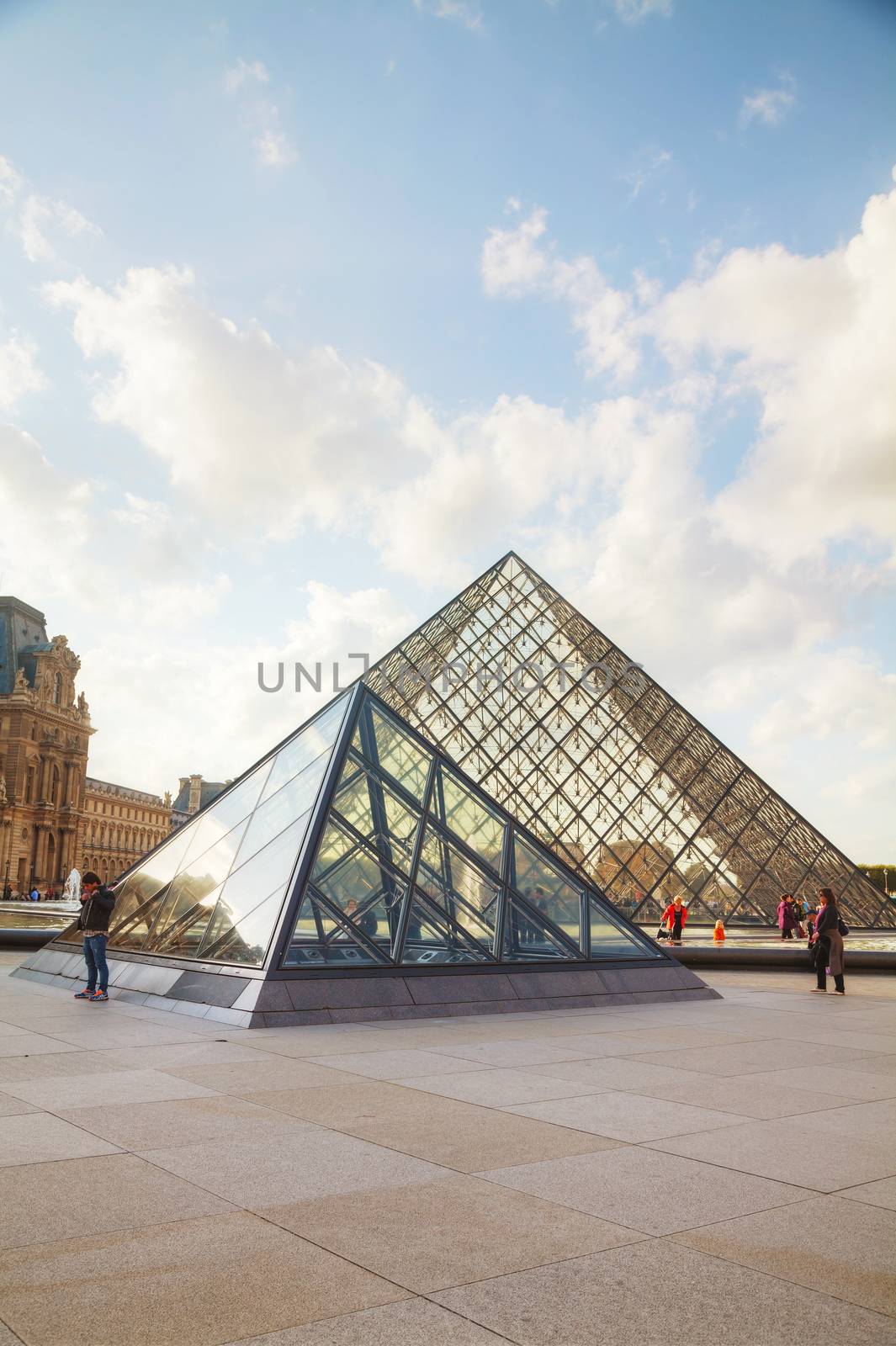 PARIS - OCTOBER 9: The Louvre Pyramid on October 9, 2014 in Paris, France. It serves as the main entrance to the Louvre Museum. Completed in 1989 it has become a landmark of Paris.
