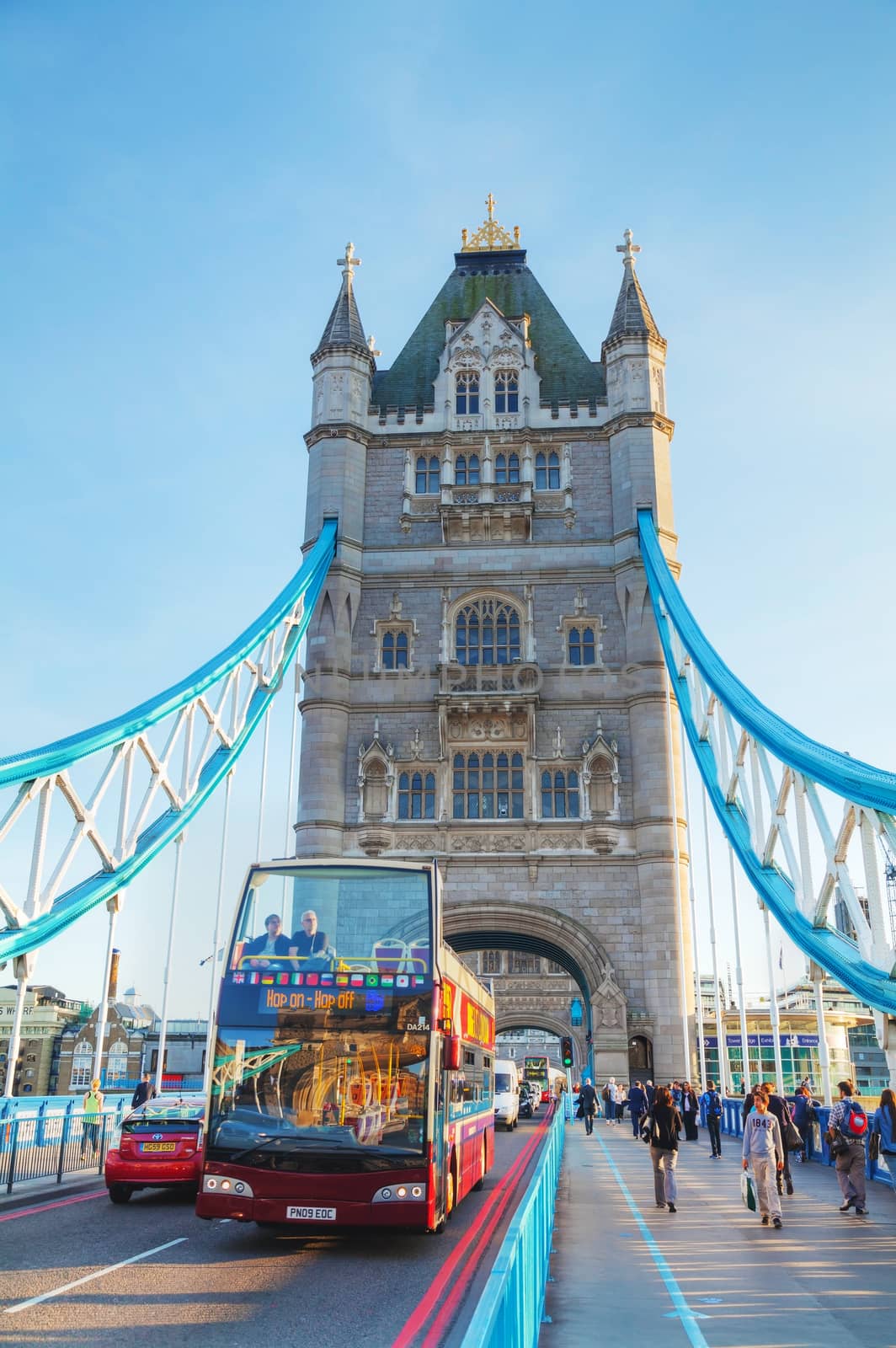 LONDON - APRIL 14: Tower bridge with a touristic double-decker bus on April 14, 2015 in London, UK. It (built 1886–1894) is a combined bascule and suspension bridge in London, England which crosses the River Thames.