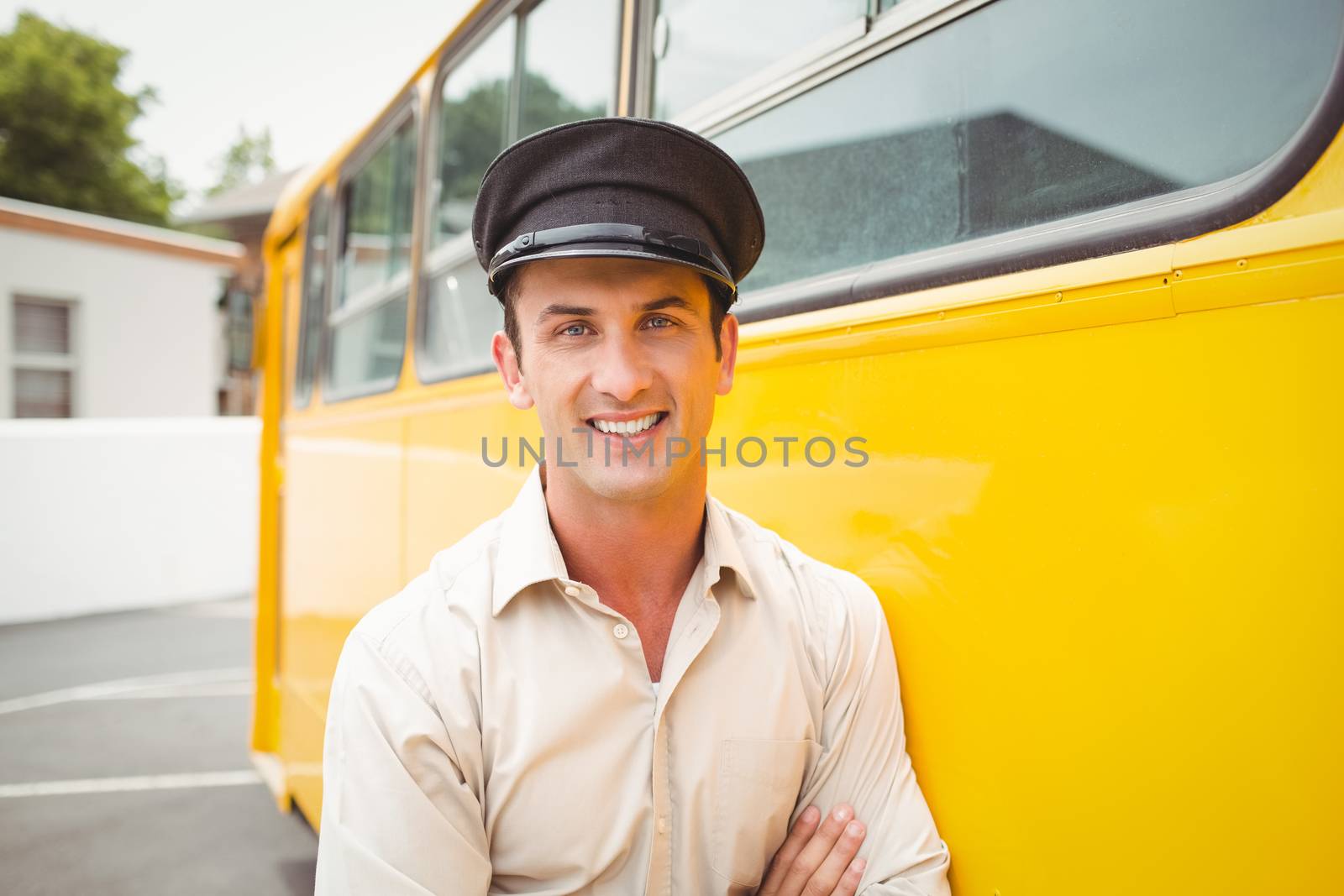 Smiling bus driver looking at camera outside the elementary school