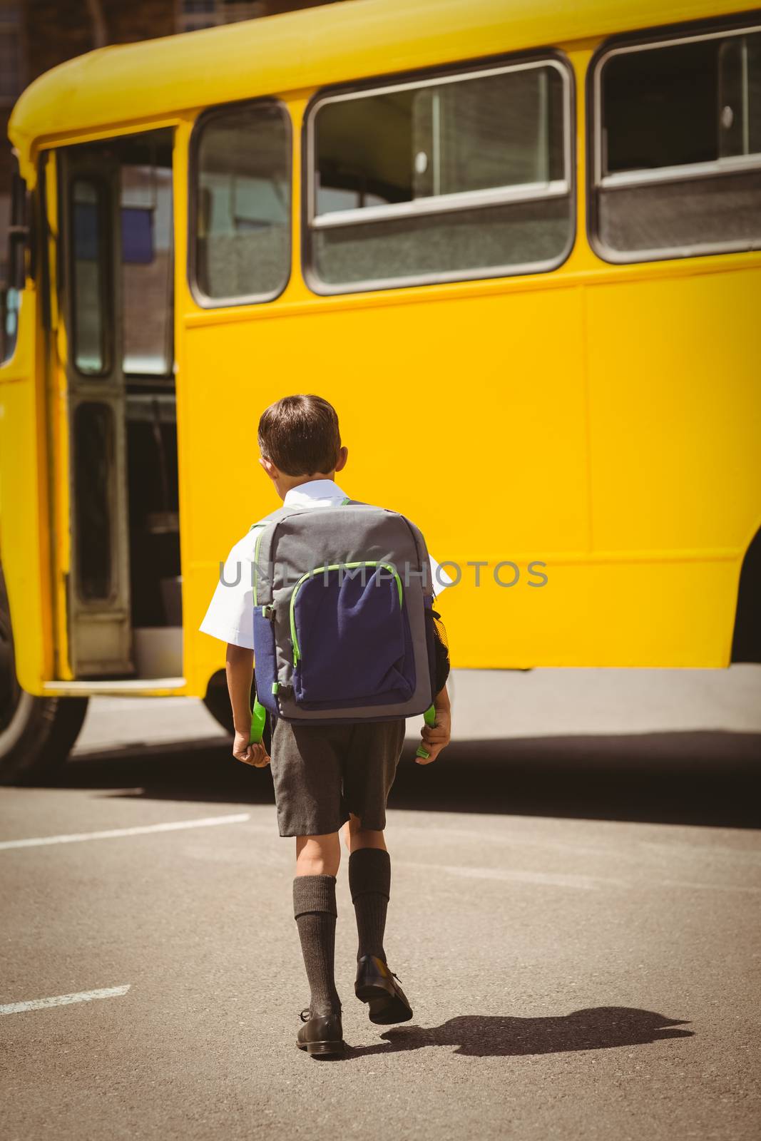 Cute pupil walking to the school bus by Wavebreakmedia