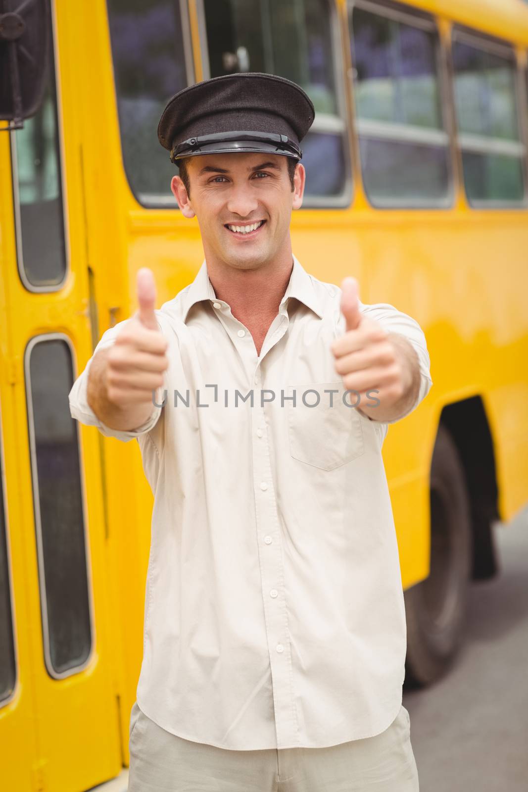 Smiling bus driver looking at camera outside the elementary school